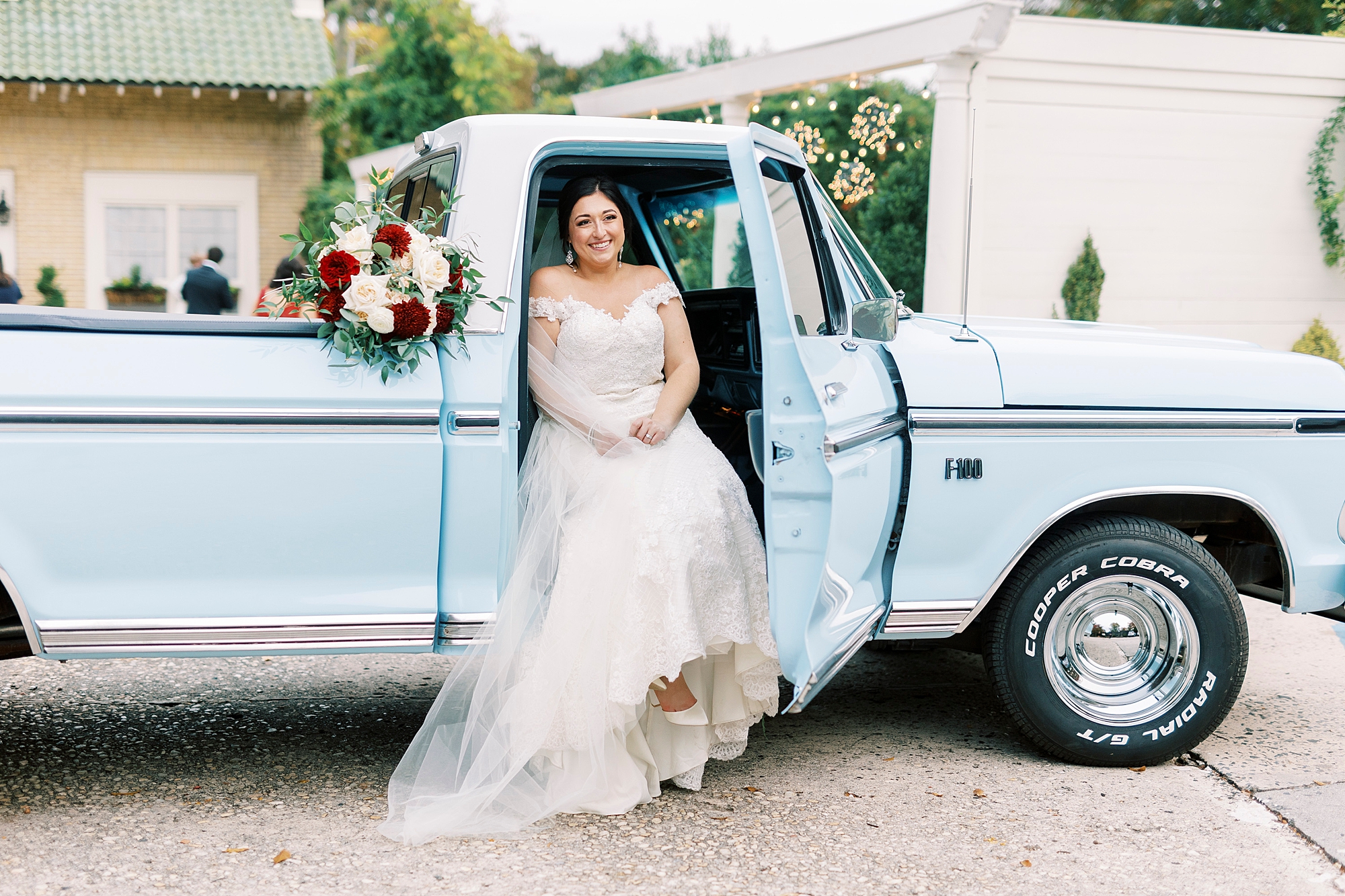 bride sits in front seat of resorted blue Ford truck