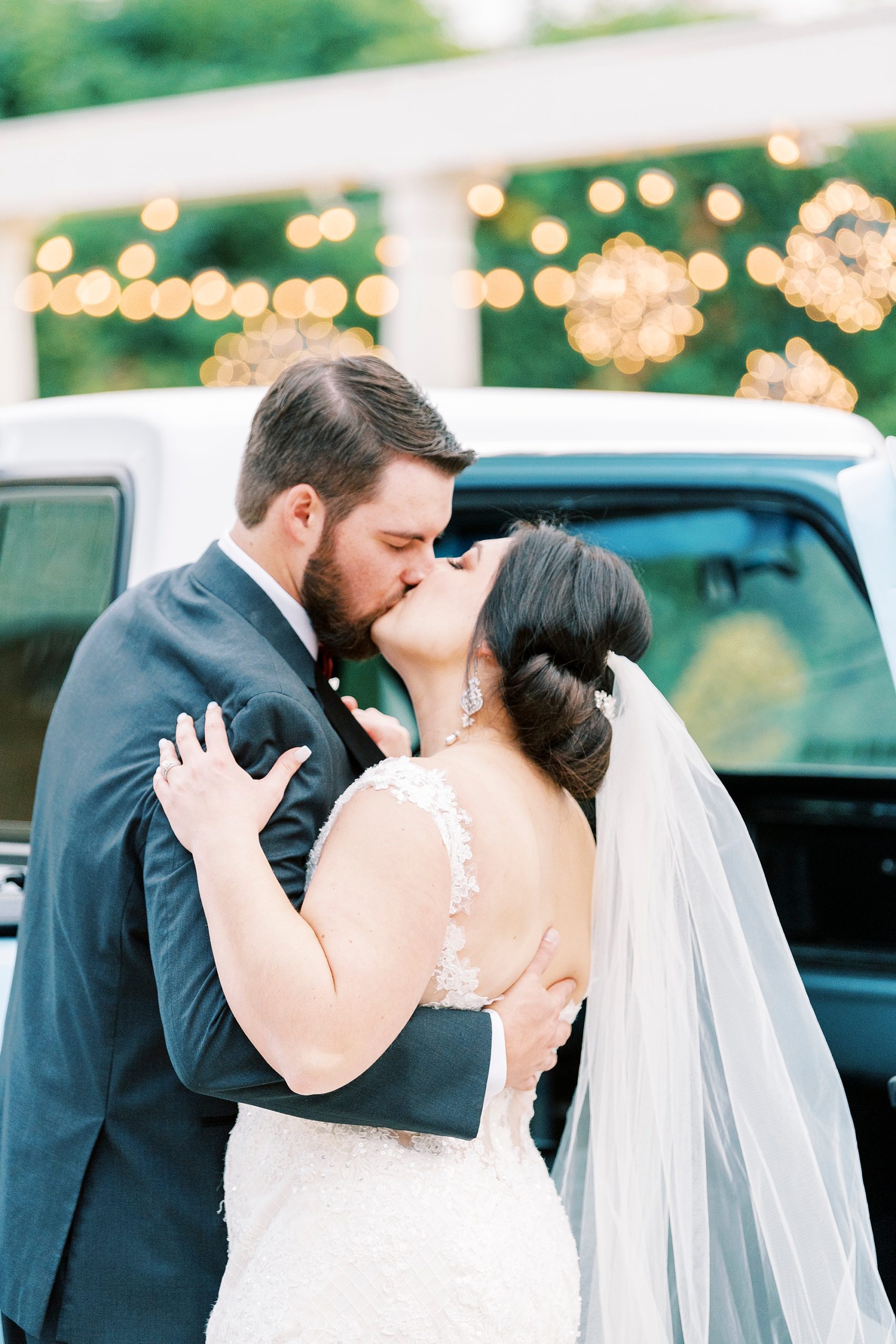 bride and groom kiss in front of resorted blue Ford truck