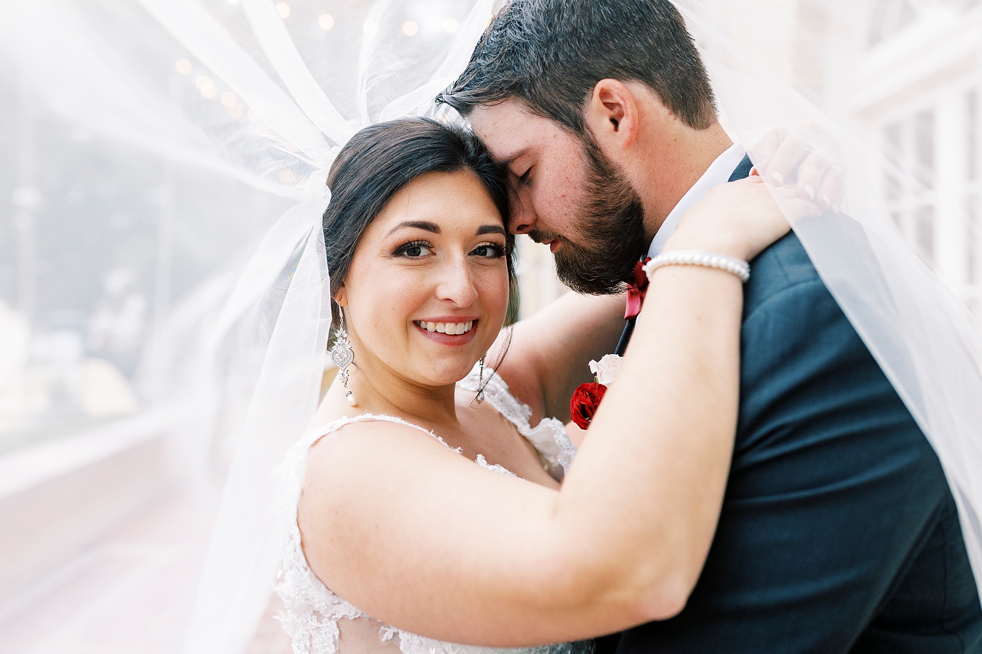 groom nuzzles bride's cheek under veil 