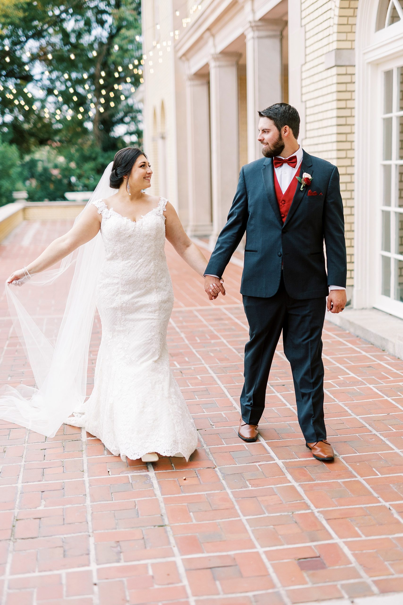 bride and groom hold hands walking on brick patio at Separk Mansion