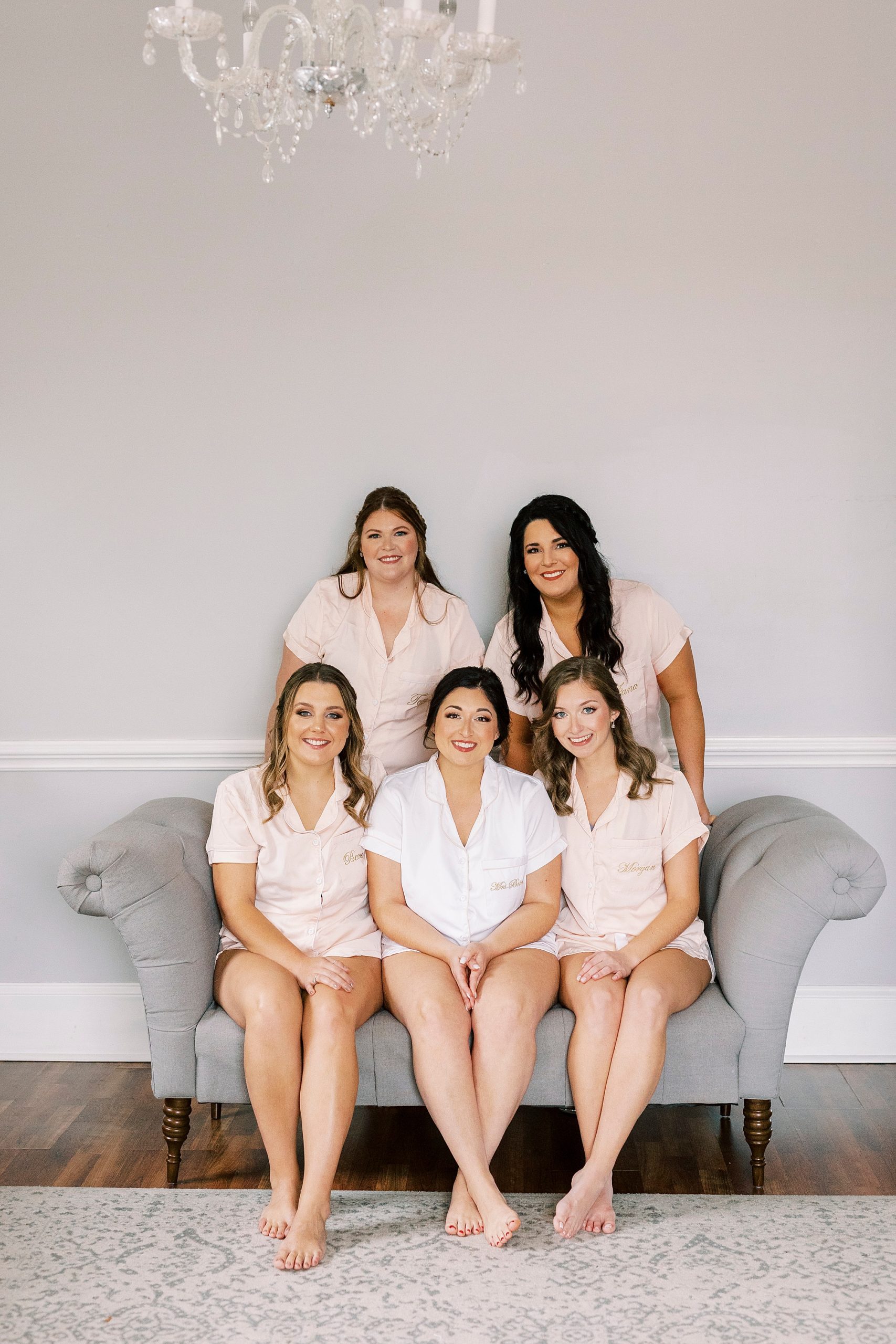 bride and bridesmaids pose on couch in bridal suite of Separk Mansion