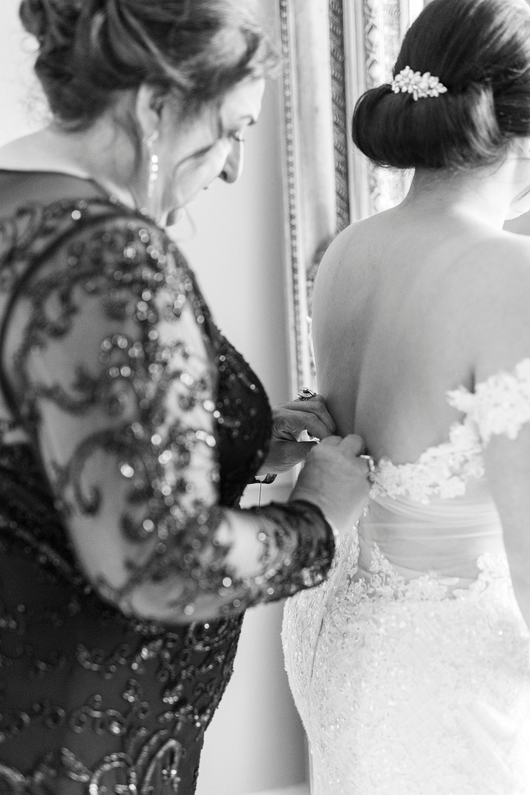 mother helps bride into wedding gown for fall wedding at Separk Mansion