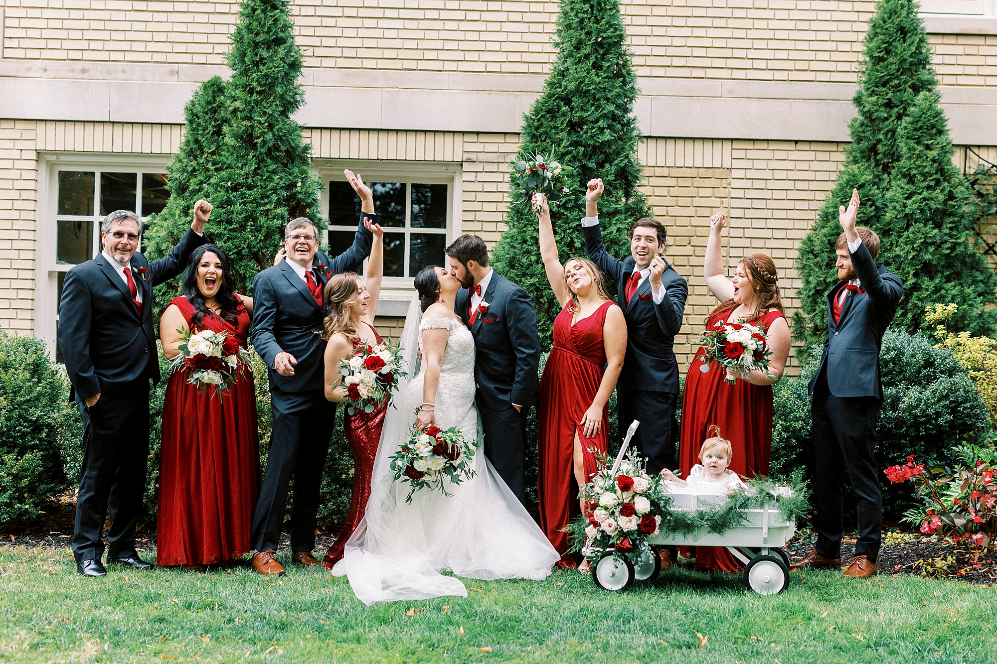 newlyweds kiss while wedding party cheers 