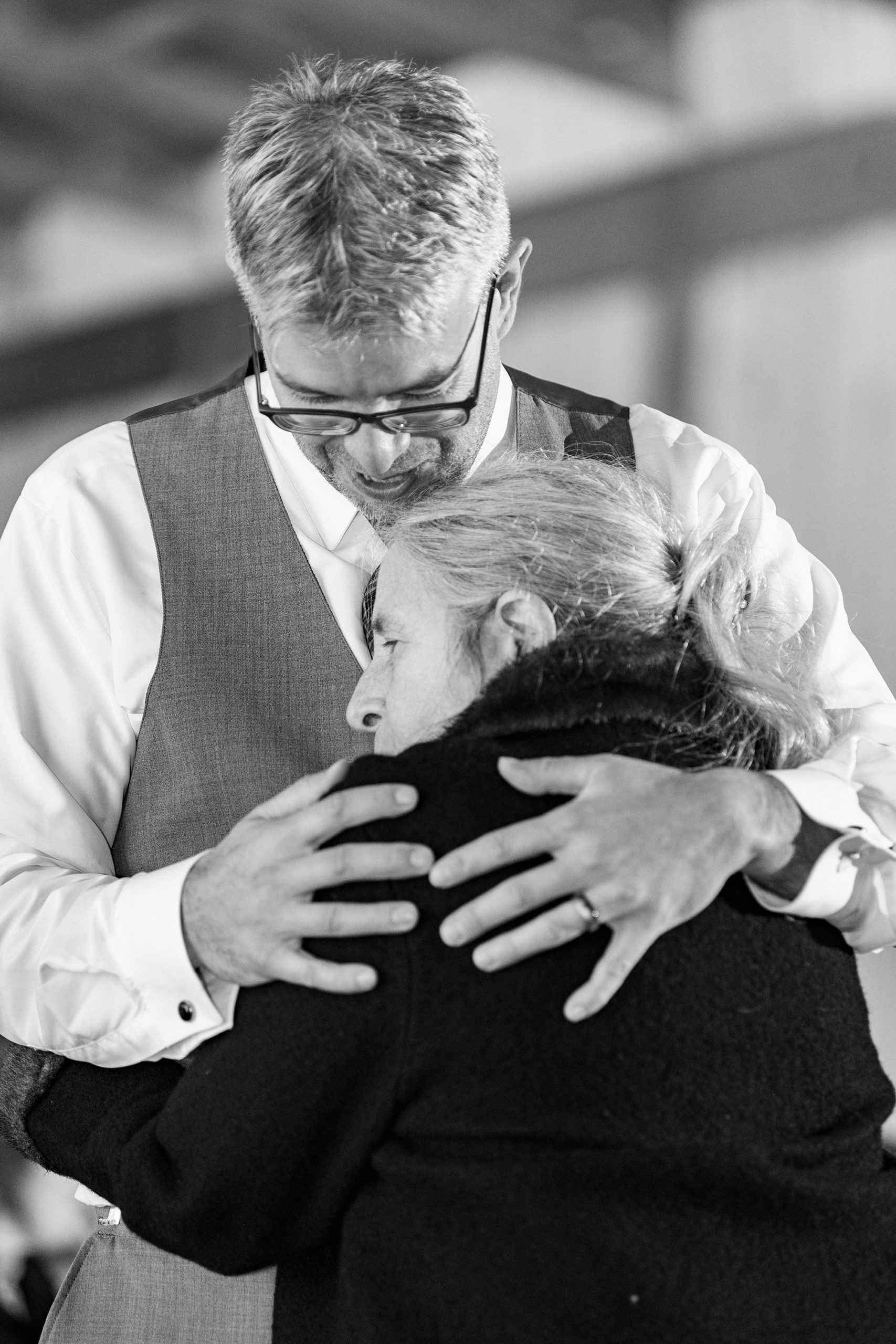 groom hugs mother to his chest during dance at Monroe NC reception 