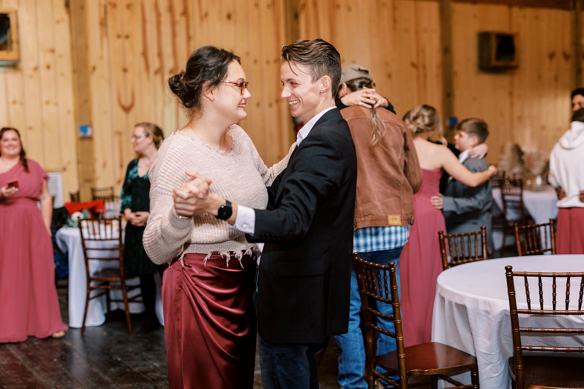 bridesmaid dances with guest in suit 
