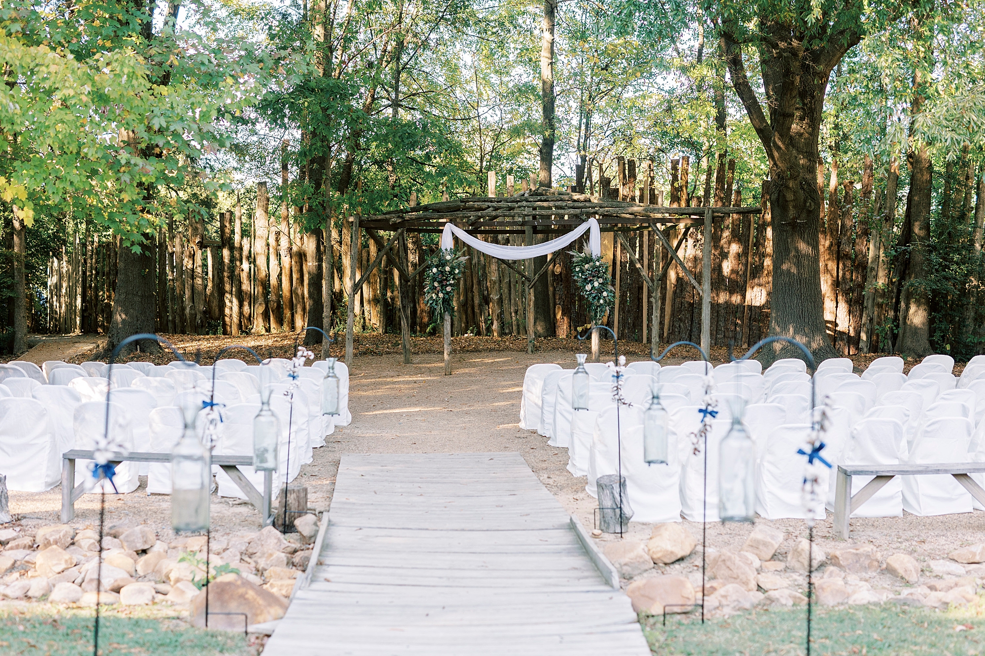 wedding ceremony site with wooden arbor at the Gin at Aw Shucks Farm