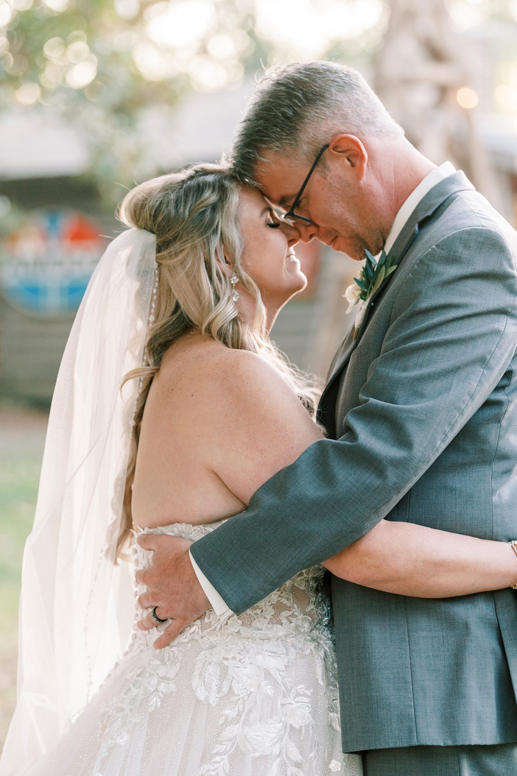 bride and groom hug each other touching noses 