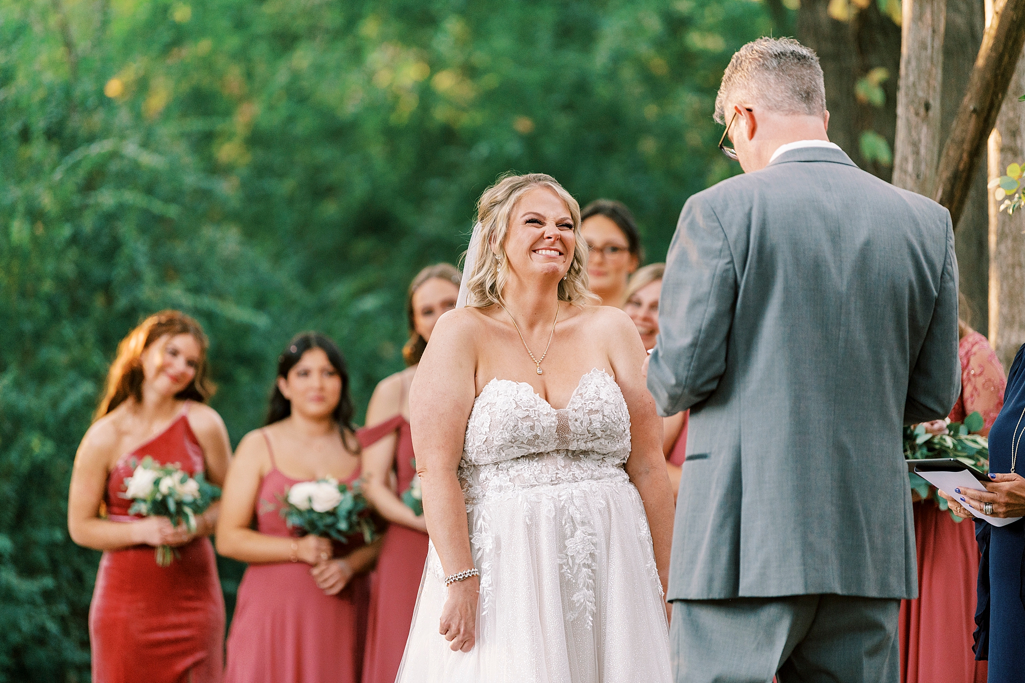 bride smiles up at groom while he reads vows during NC wedding ceremony 