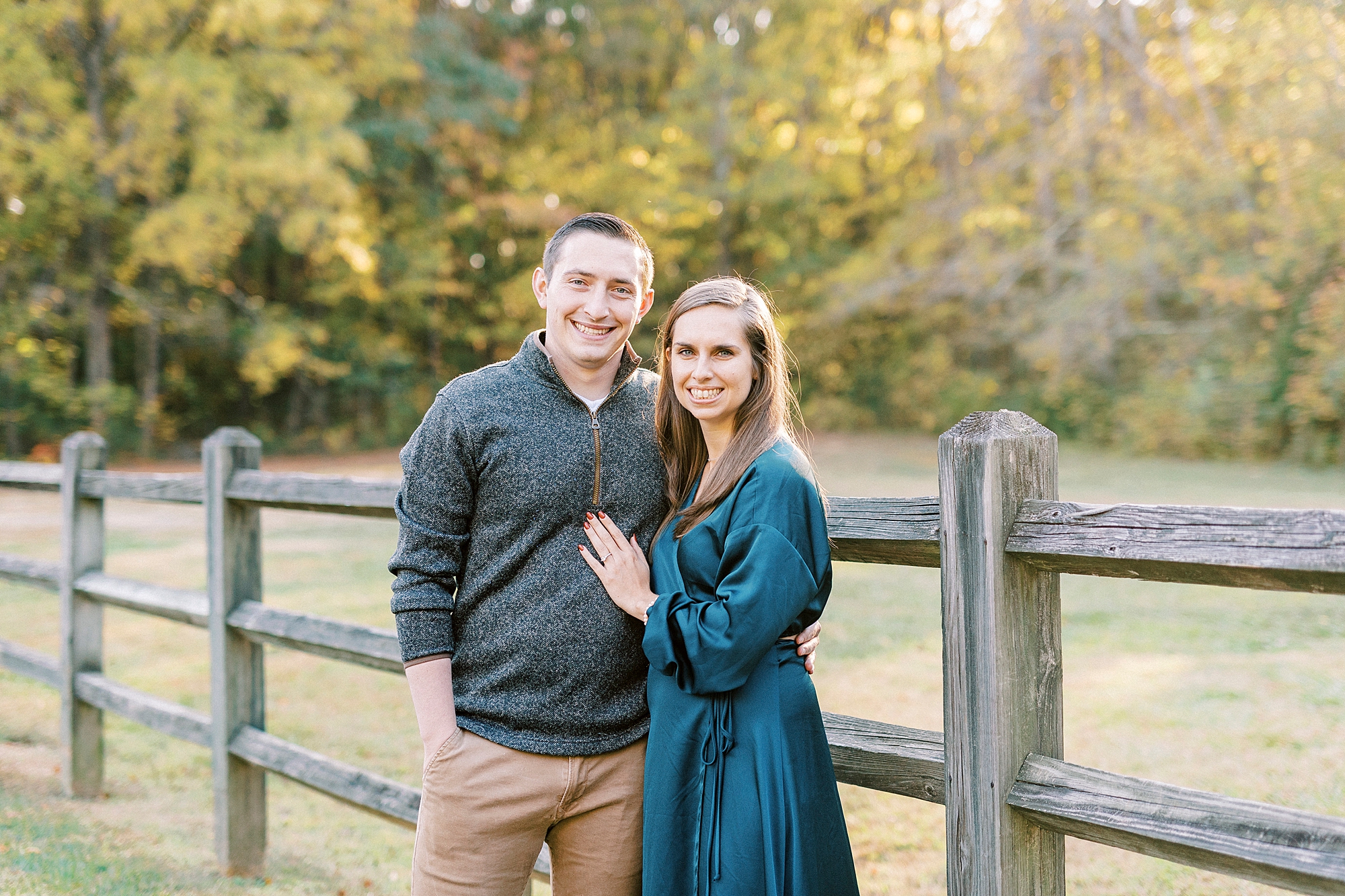 engaged couple hugs by wooden fence during Latta Nature Preserve engagement session 