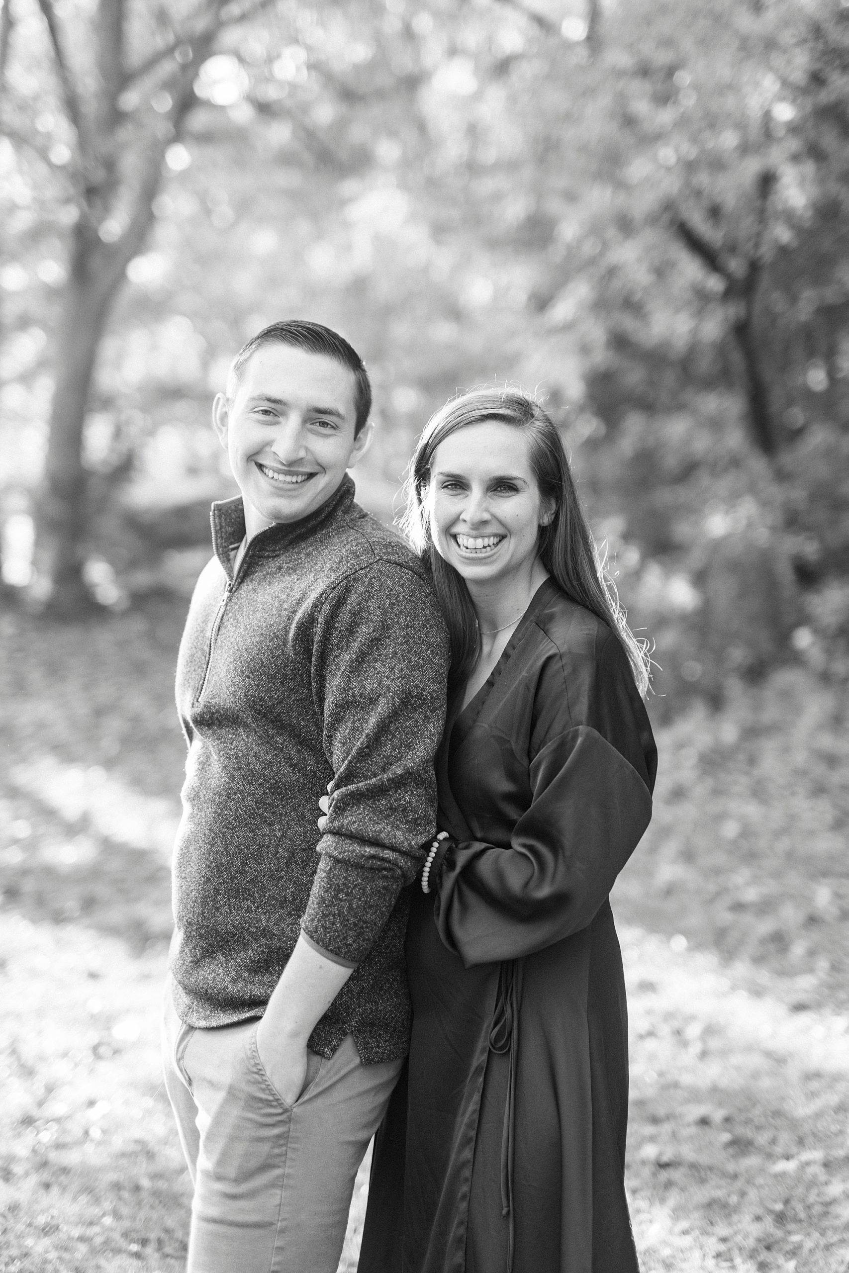 woman hugs fiancee from behind during fall engagement photos 