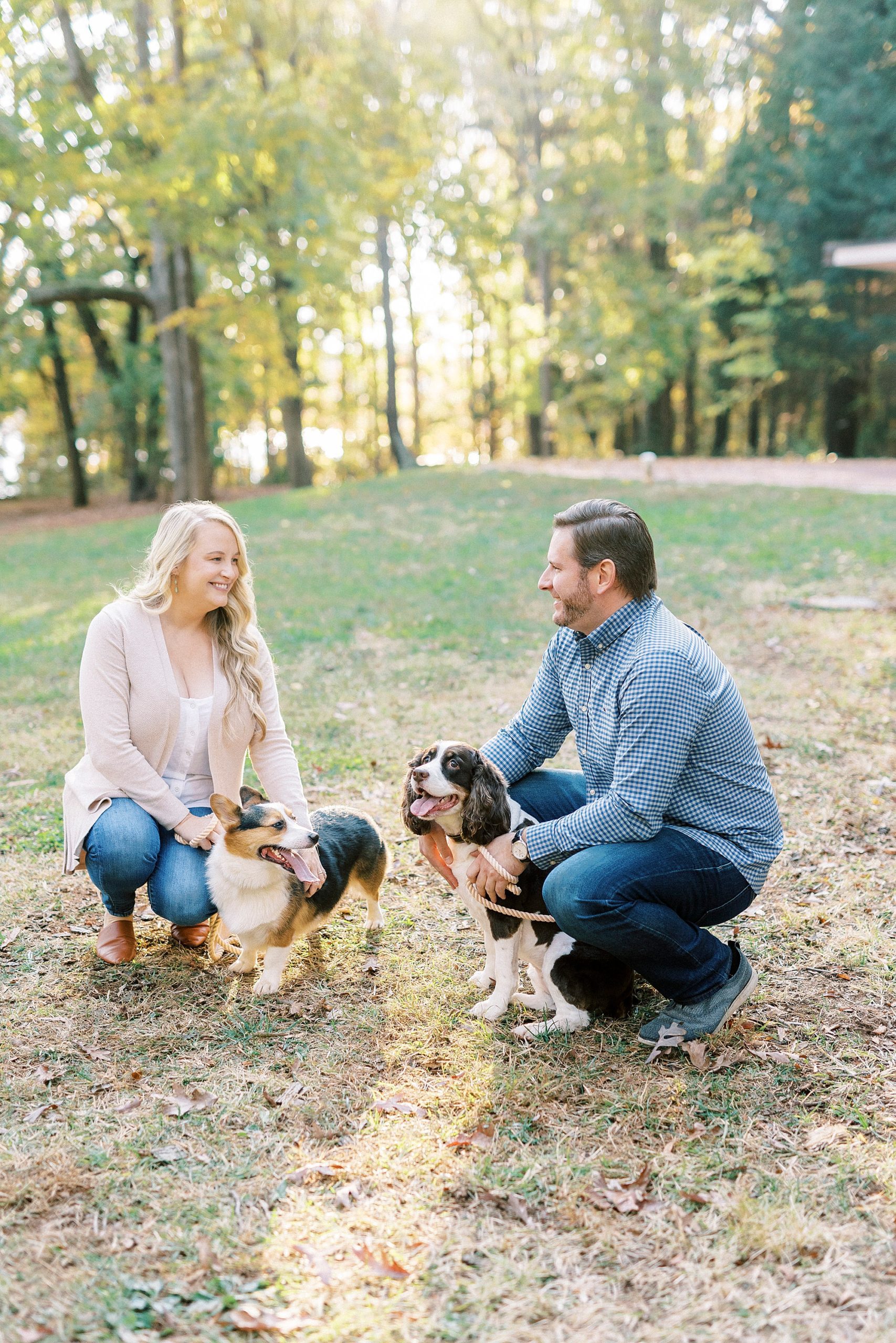 bride and groom laugh with dog during fall engagement session 