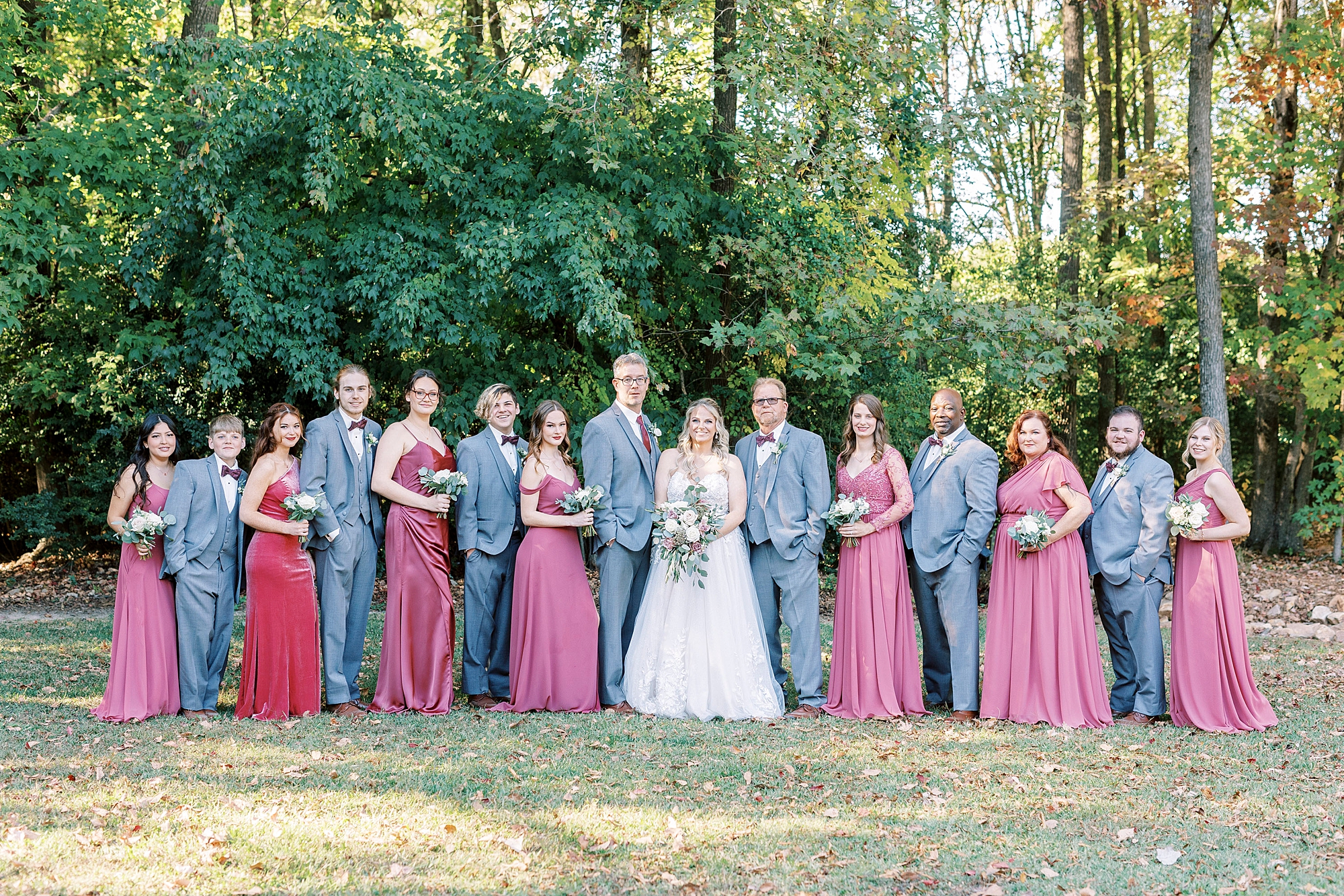 newlyweds stand with wedding party on lawn at the Gin at Aw Shucks Farm