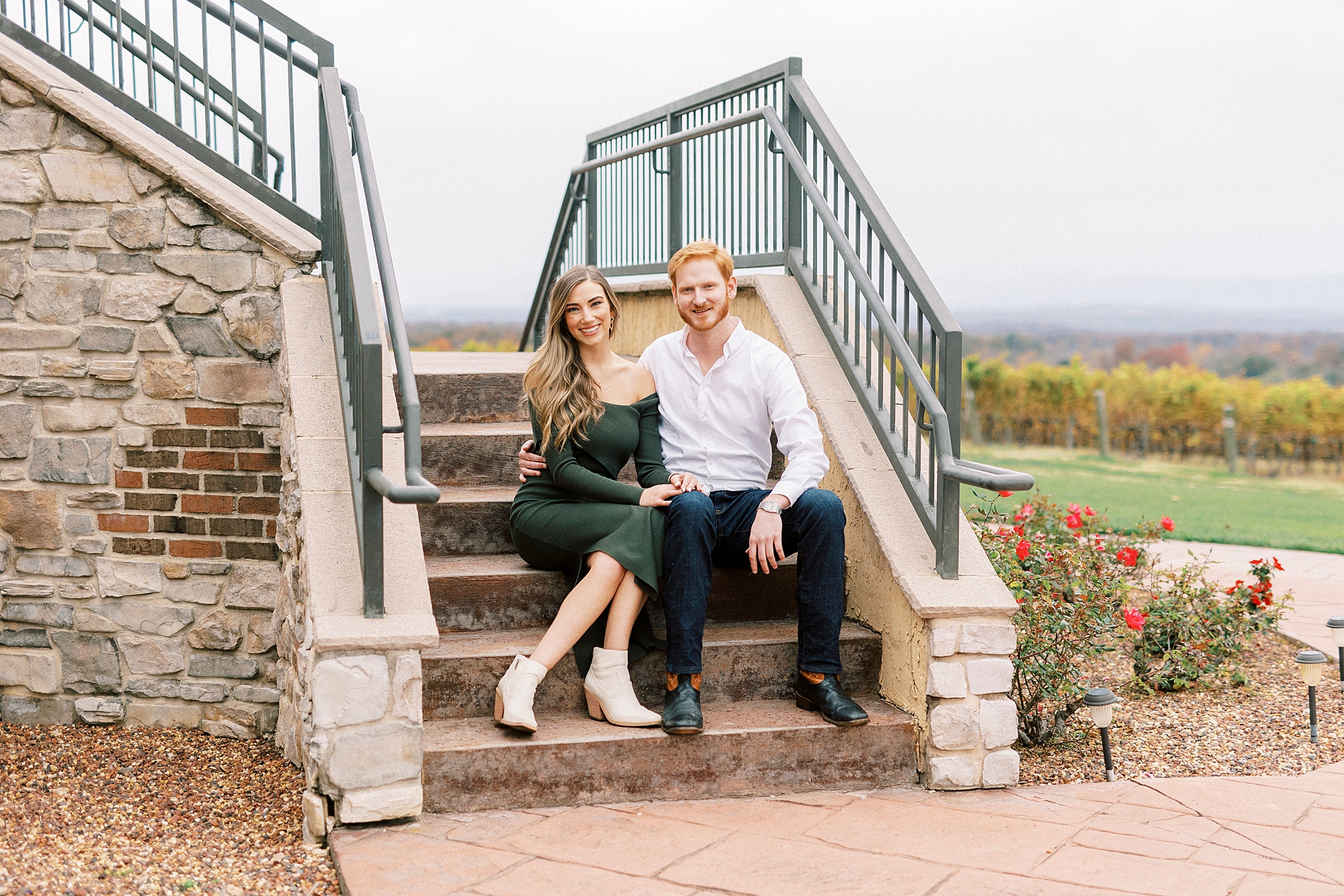 engaged couple sits together on steps of staircase in NC