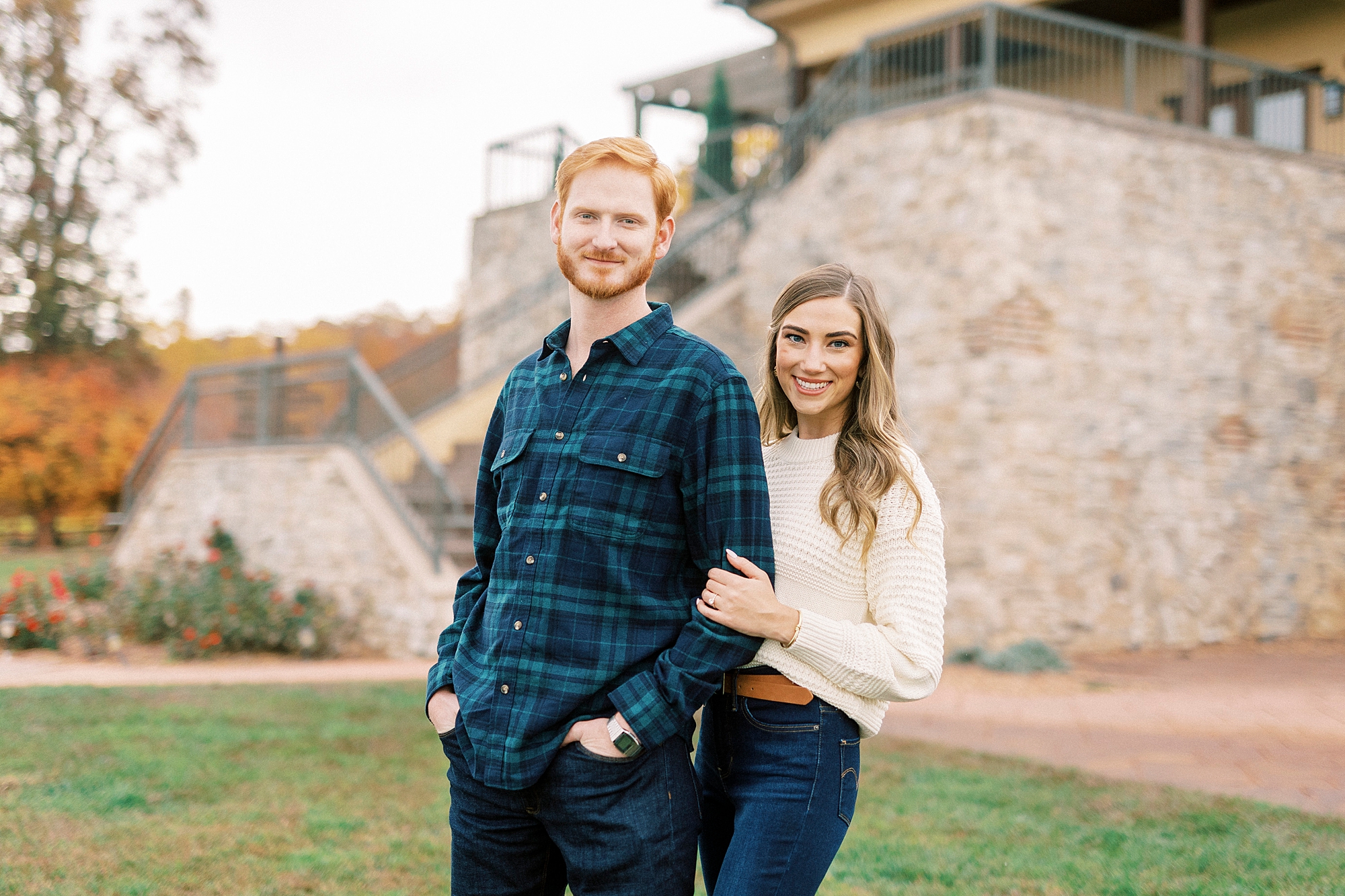 bride holds groom's arm during fall engagement portraits at Raffaldini Vineyards