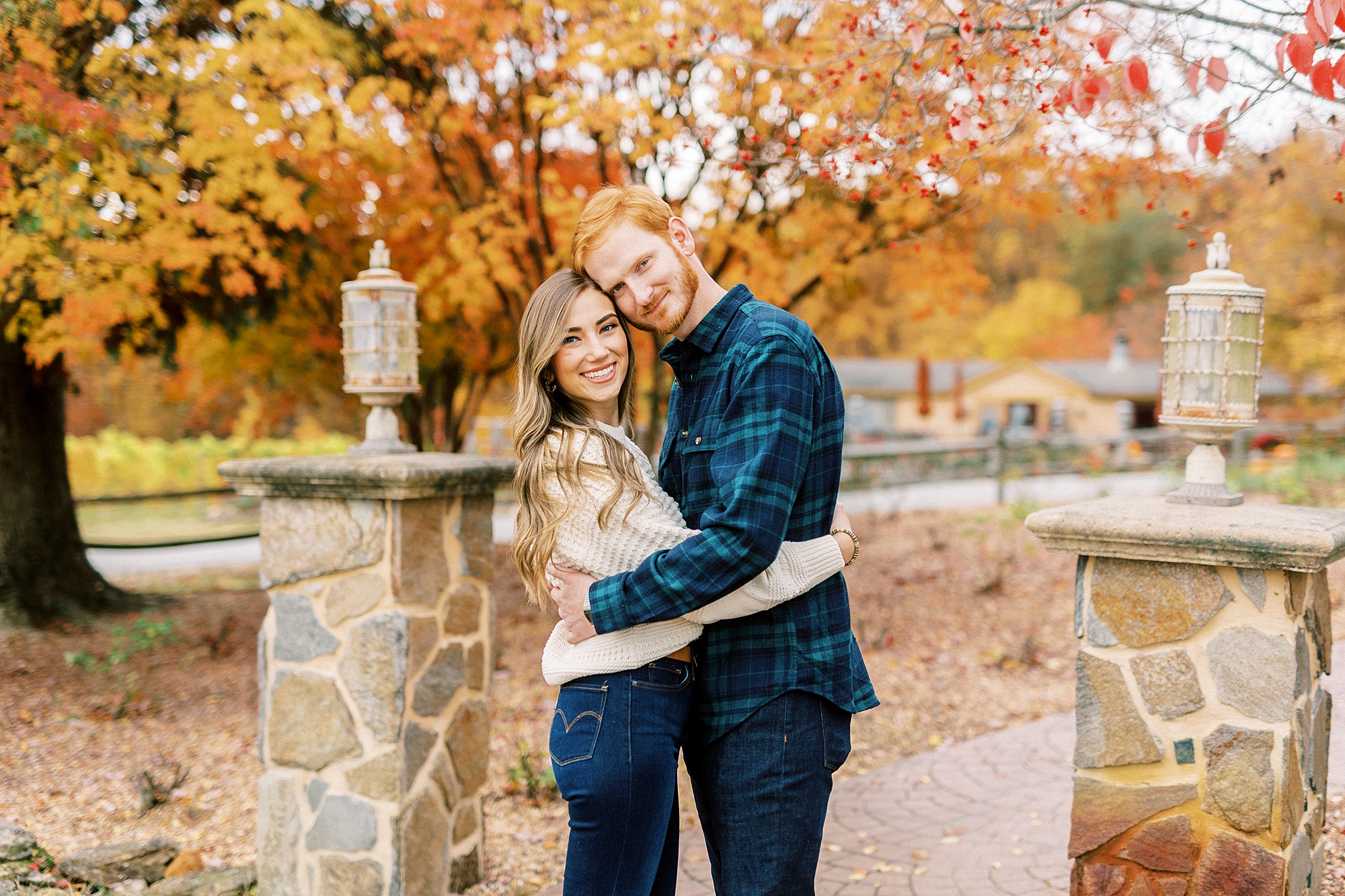 engaged couple hugs by tree with orange leaves in North Carolina 