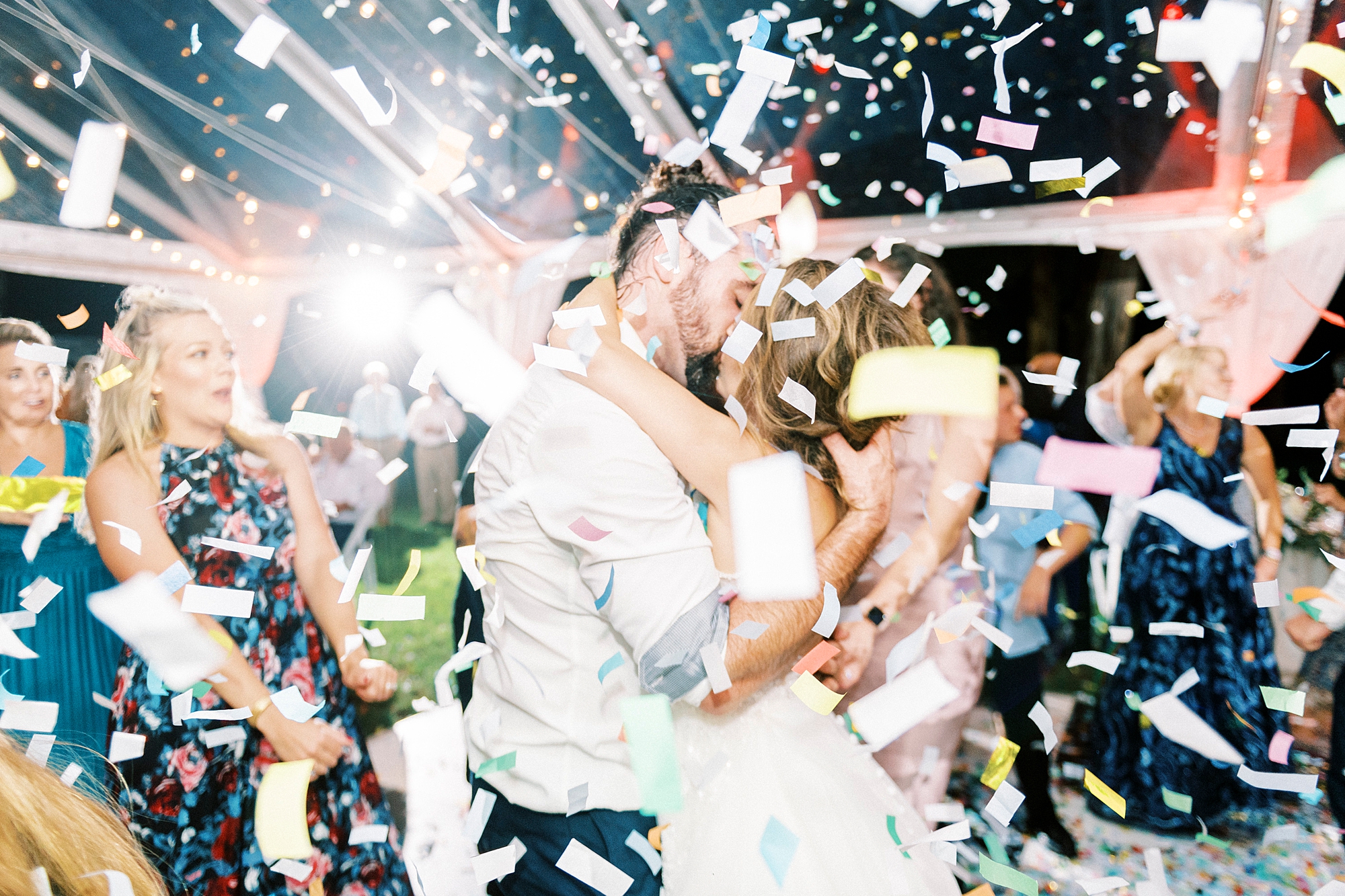 bride and groom kiss during confetti toss