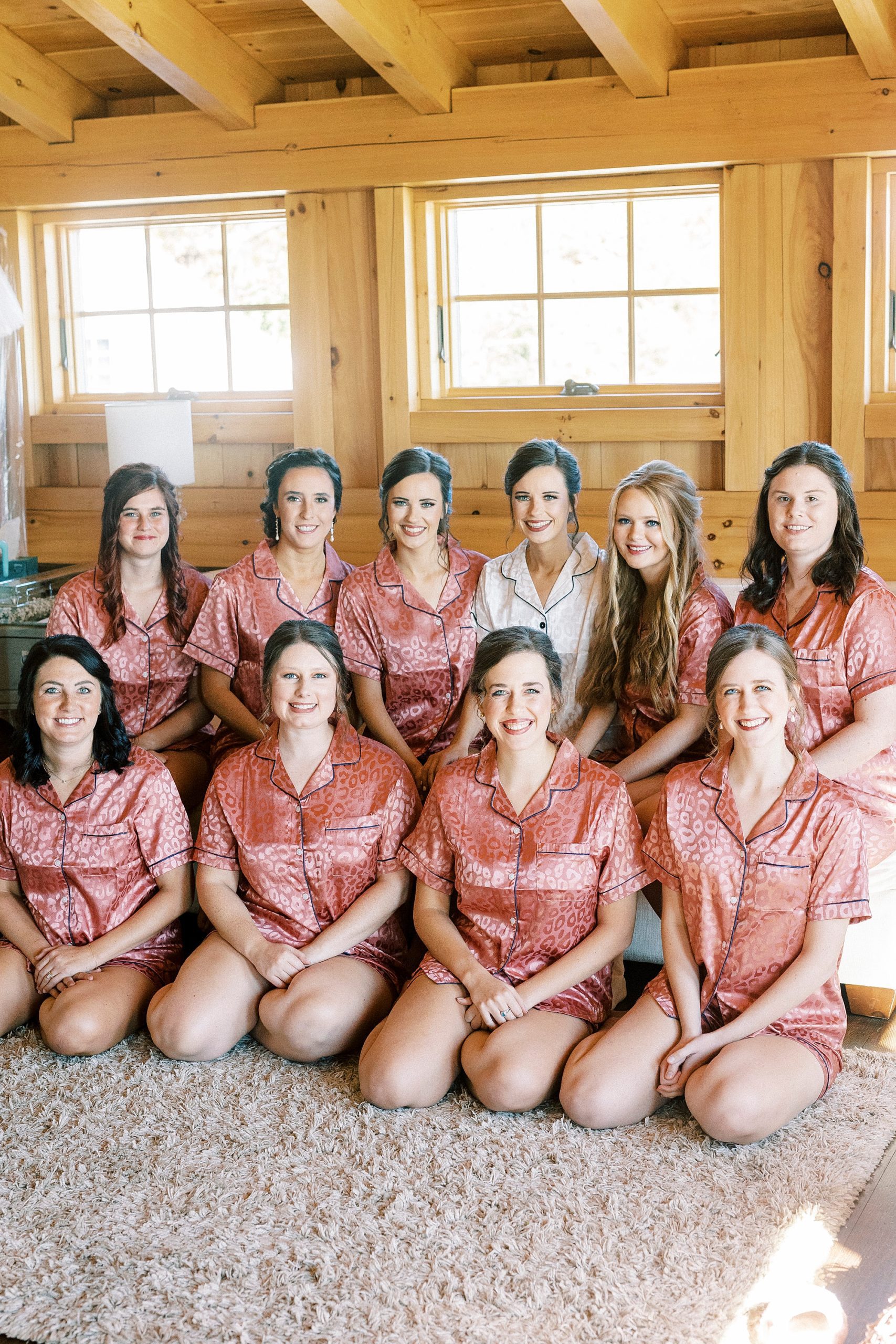 bride poses with bridesmaids in matching pink pajamas 