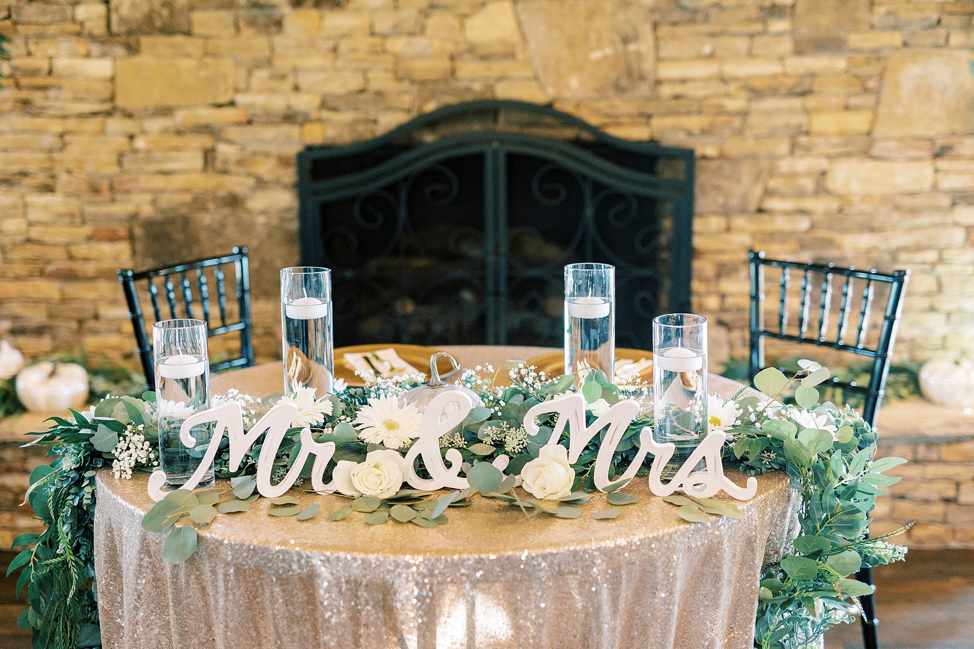 sweetheart table with rose gold tablecloth and Mr and Mrs signs 