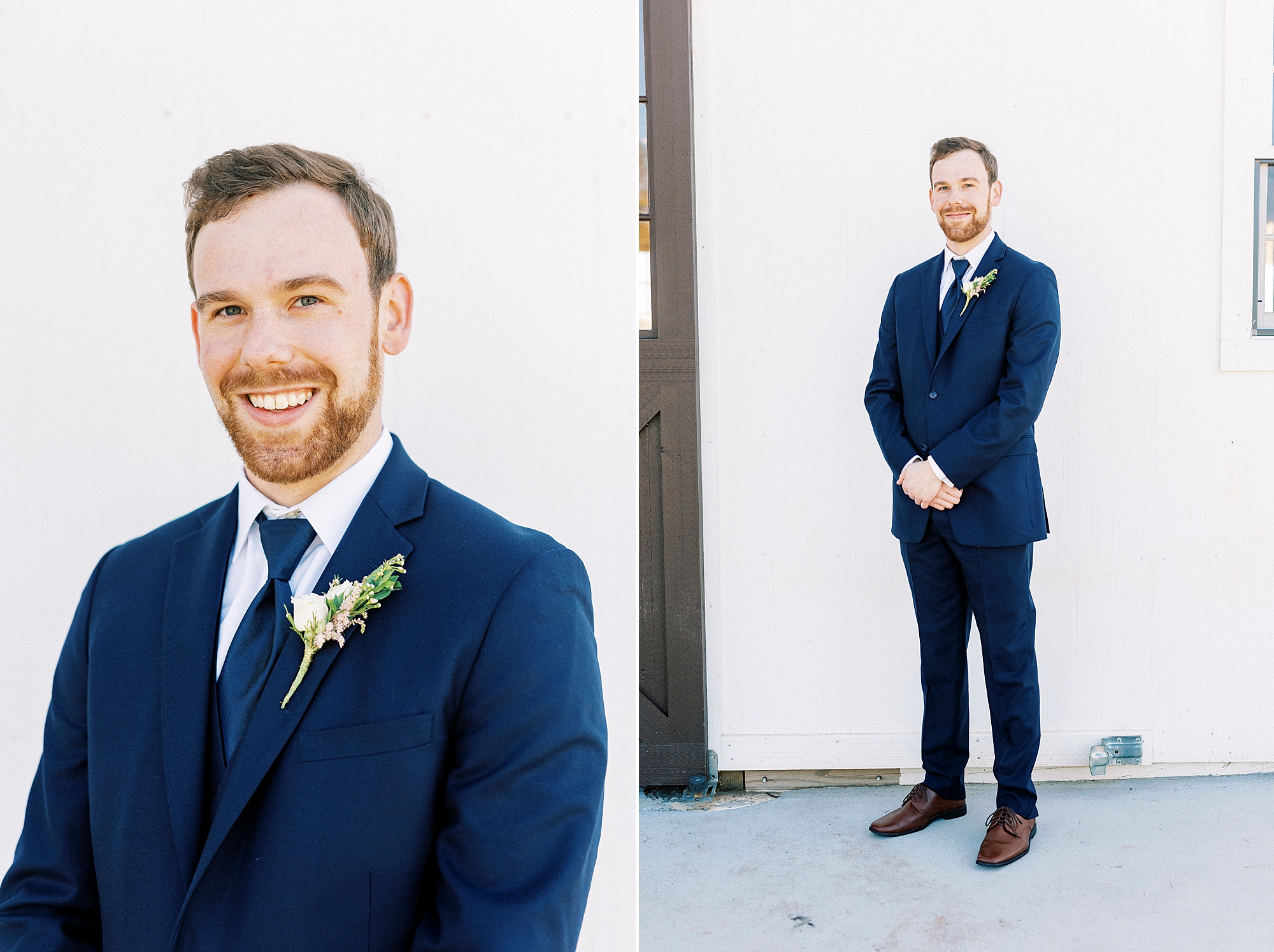 groom stands in navy suit with hands in front of him 