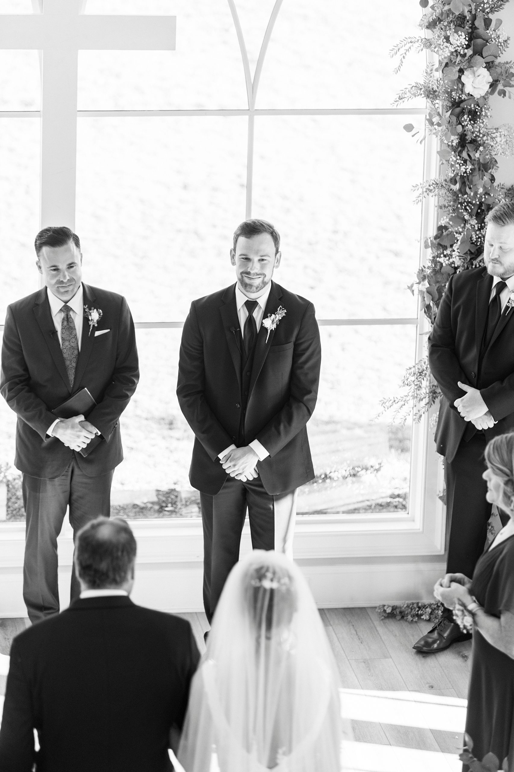 groom smile at bride walking down aisle in chapel at Chickadee Hill Farms