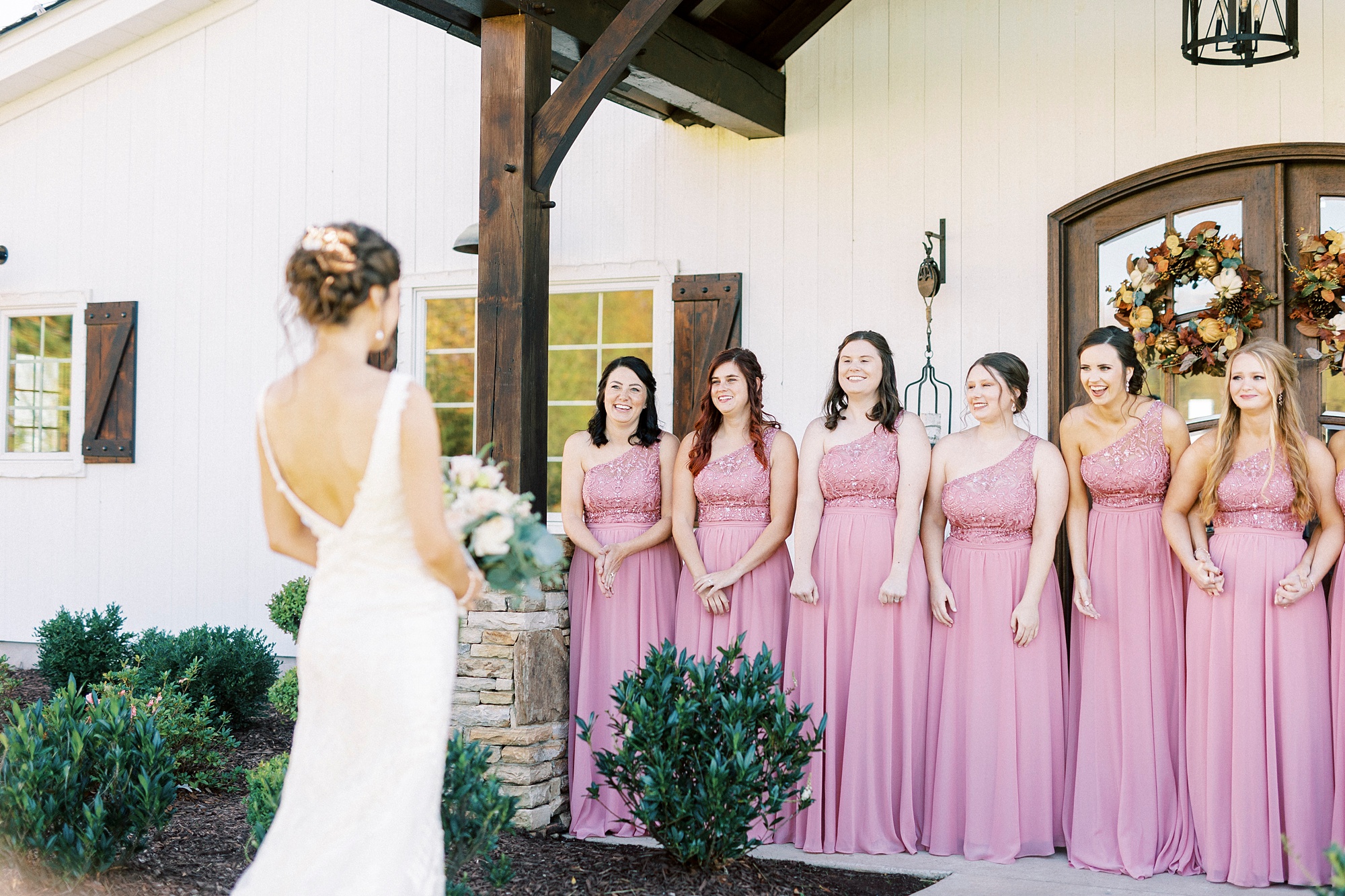bridesmaids in pink gowns gasp during first look with bride 