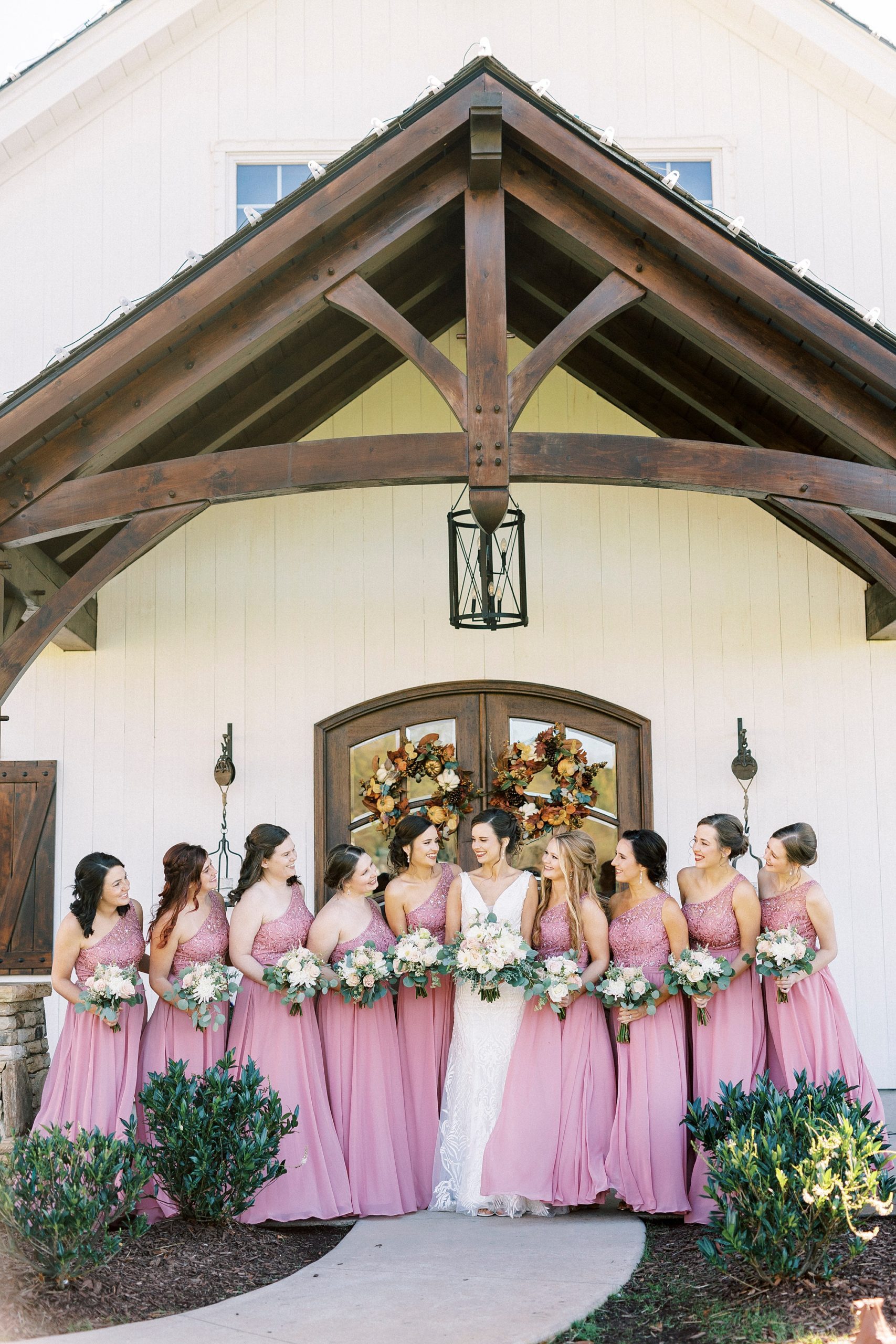 bride poses with bridesmaids in pink gowns at Chickadee Hill Farms
