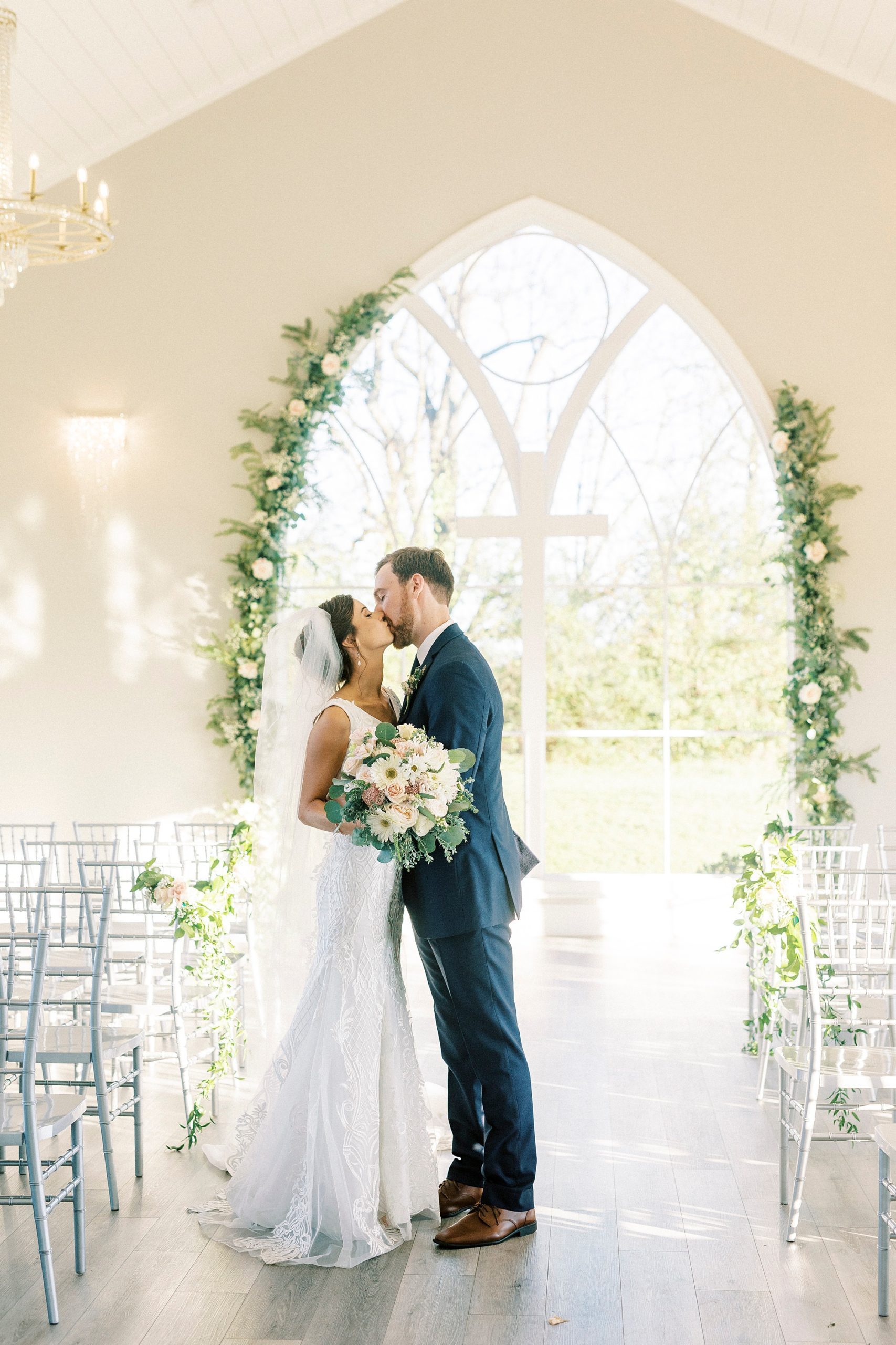 bride and groom kiss inside chapel at Chickadee Hill Farms