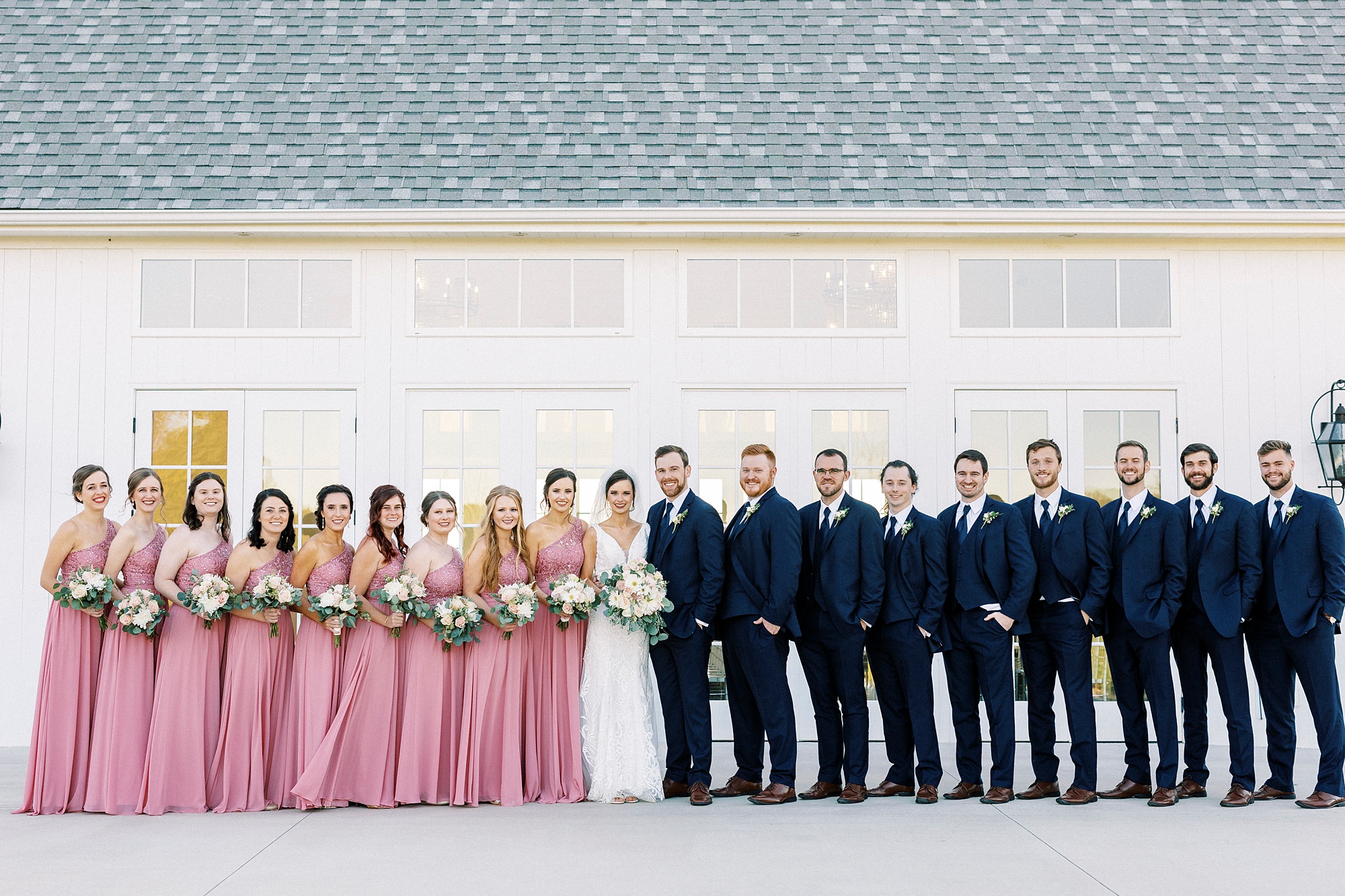 bride and groom pose with wedding party in pink and navy at Chickadee Hill Farms