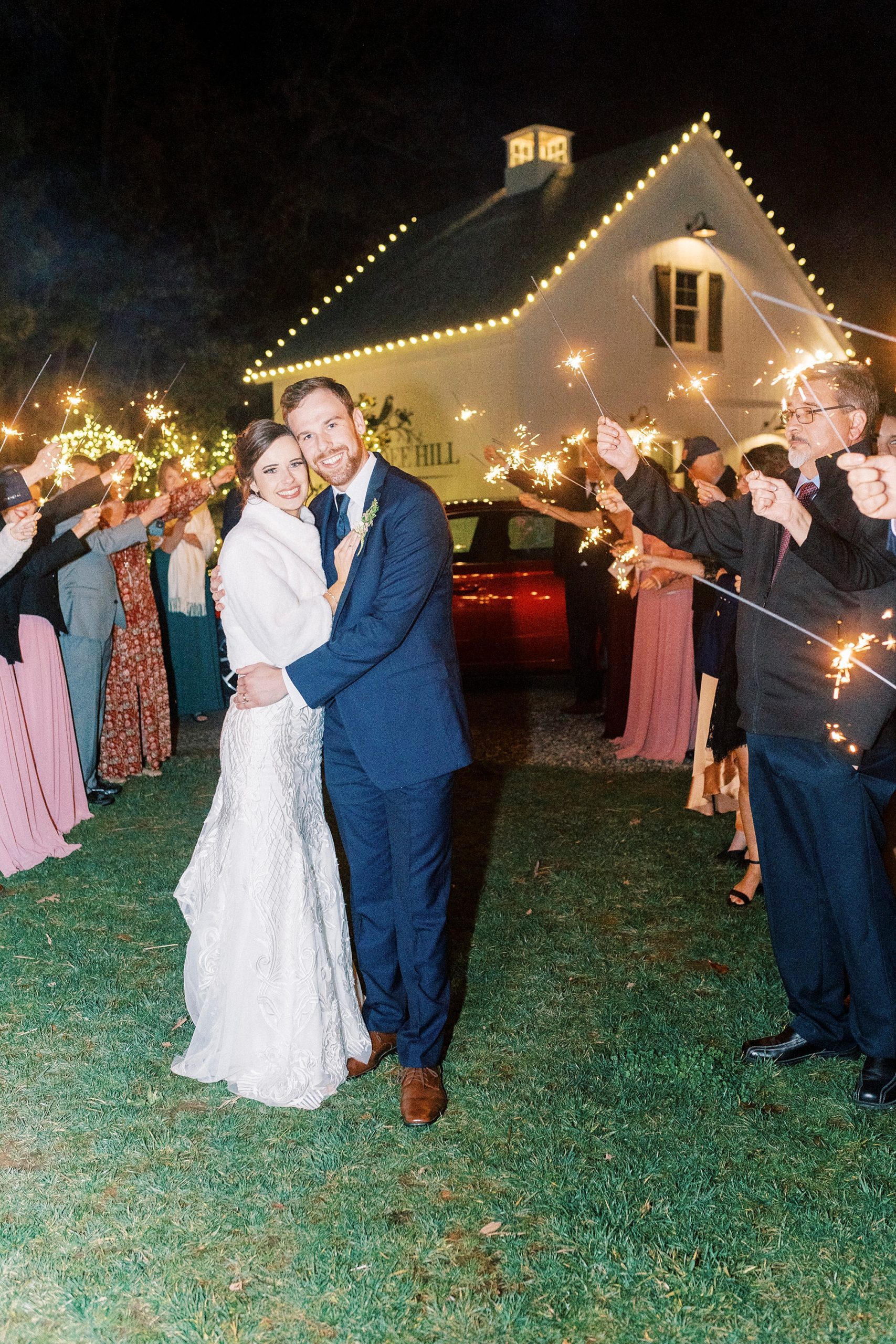 newlyweds hug during sparkler exit leaving Chickadee Hill Farms