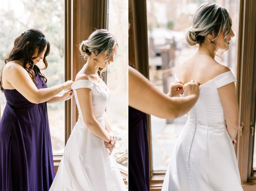 mother in purple dress helps bride into classic off-the-shoulder wedding gown 
