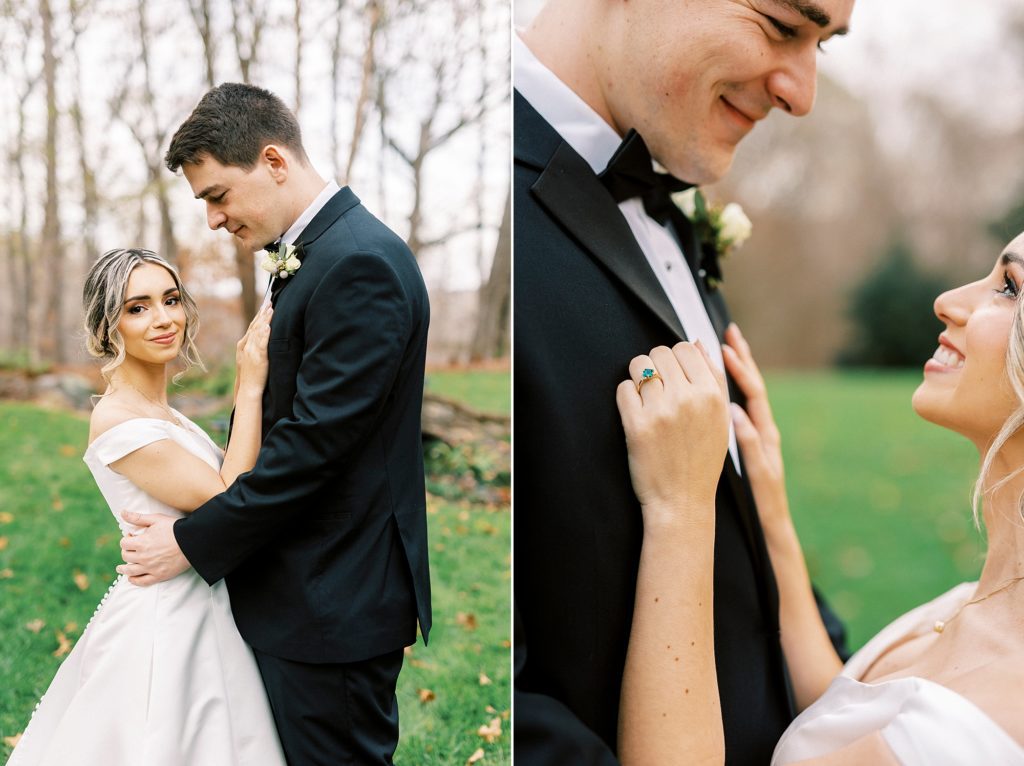 bride holds groom's lapel on black suit on lawn in the fall 