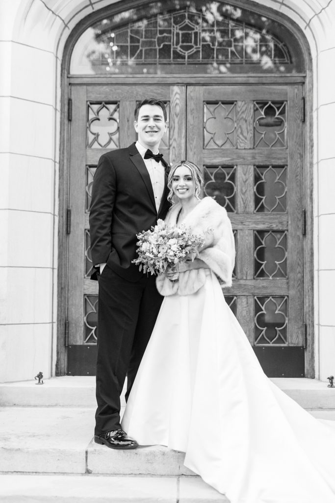 bride and groom smile on steps at St. James Lutheran Church in Concord NC
