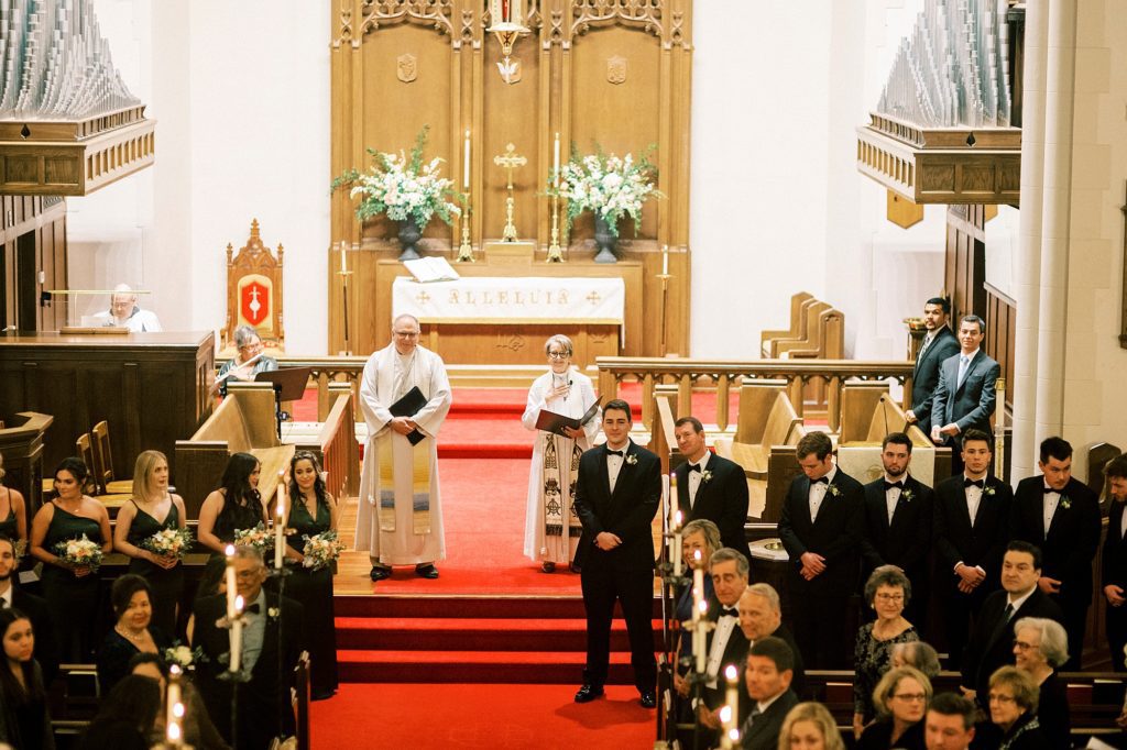 priest waits for bride with groom inside St. James Lutheran Church in Concord NC