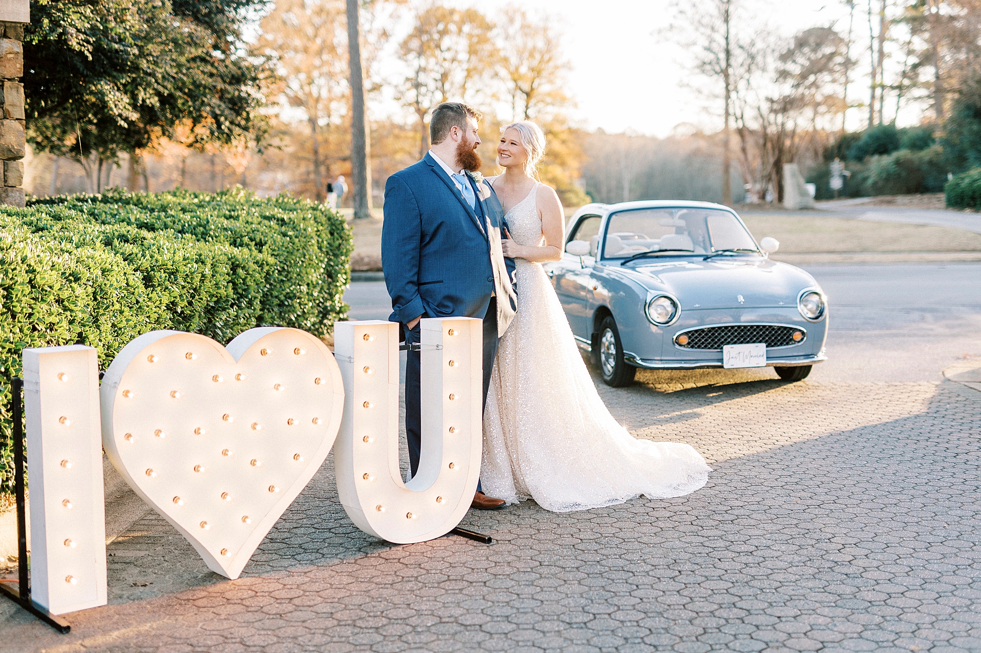 bride and groom hug by marquee lights with "I heart you" by Charlotte the Figgy 
