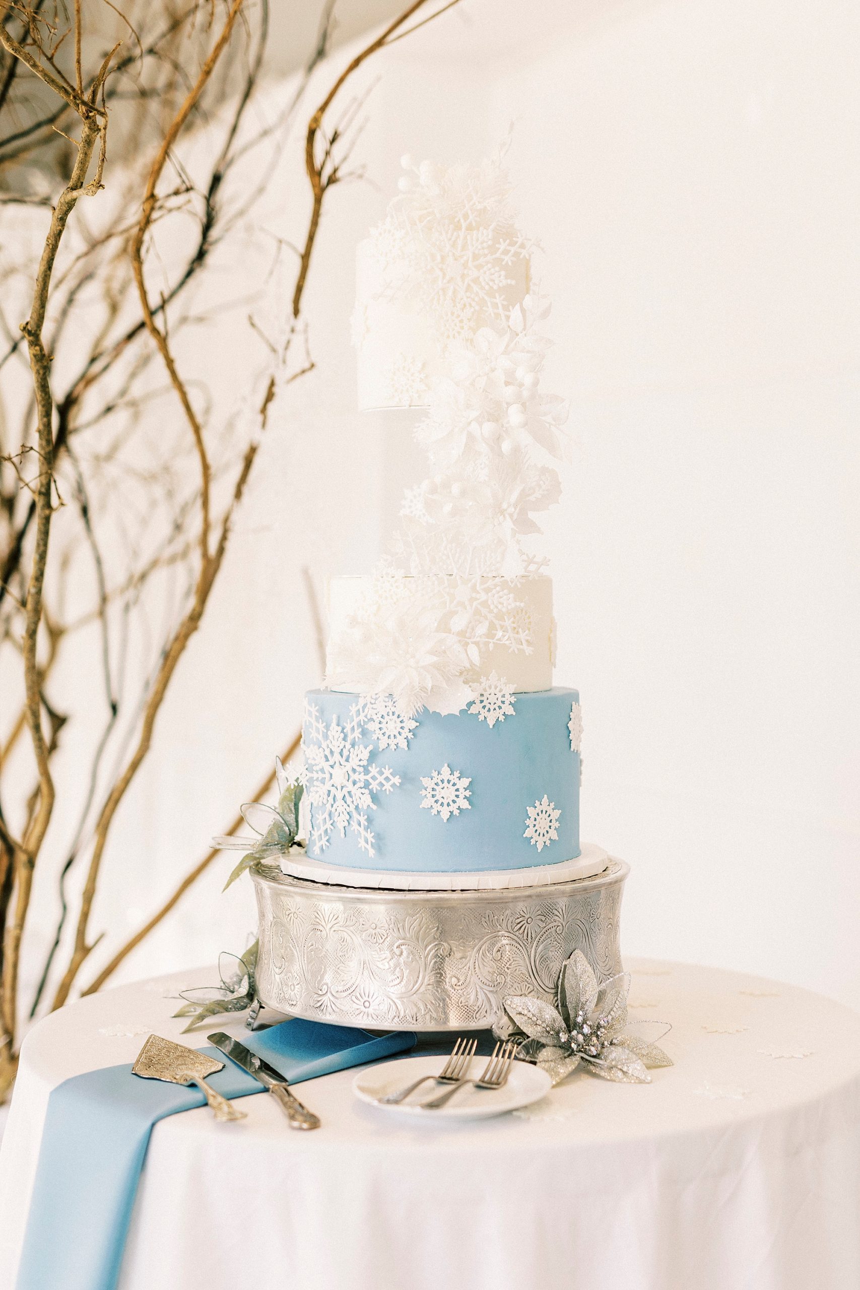 tiered wedding cake with blue tier and white snowflakes 