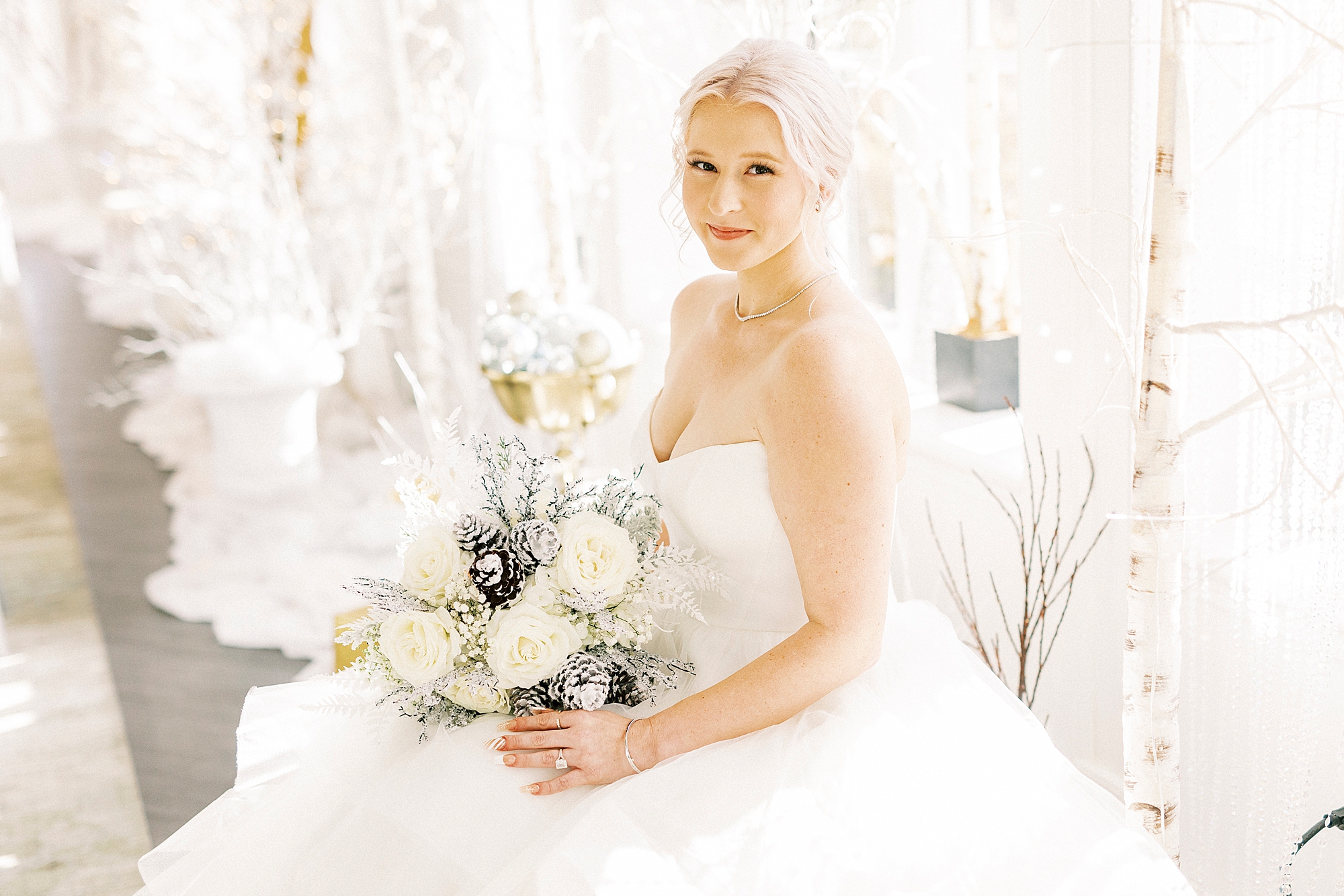 bride holds bouquet of white flowers and blue accents for winter wonderland wedding at River Run Country Club