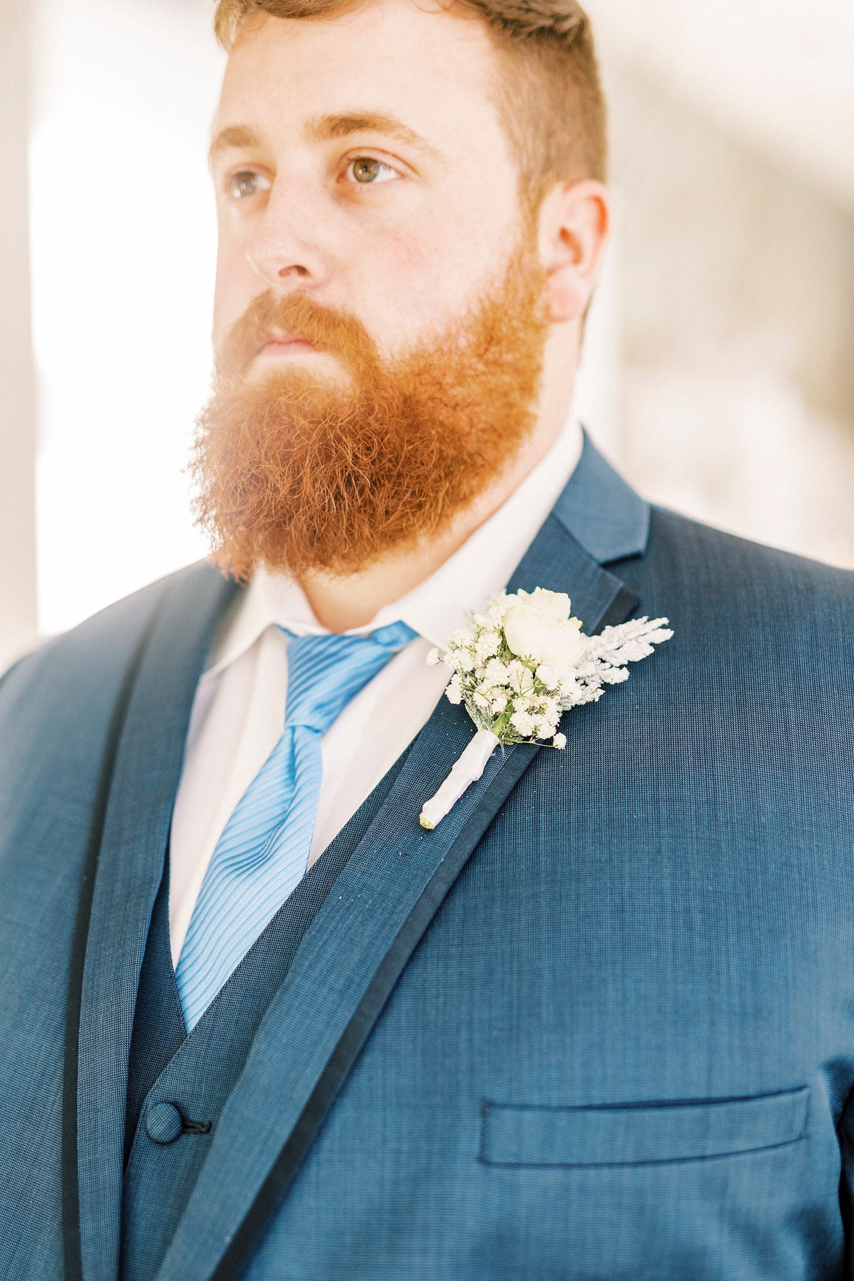 groom's navy suit with white boutonniere for winter wedding at River Run Country Club