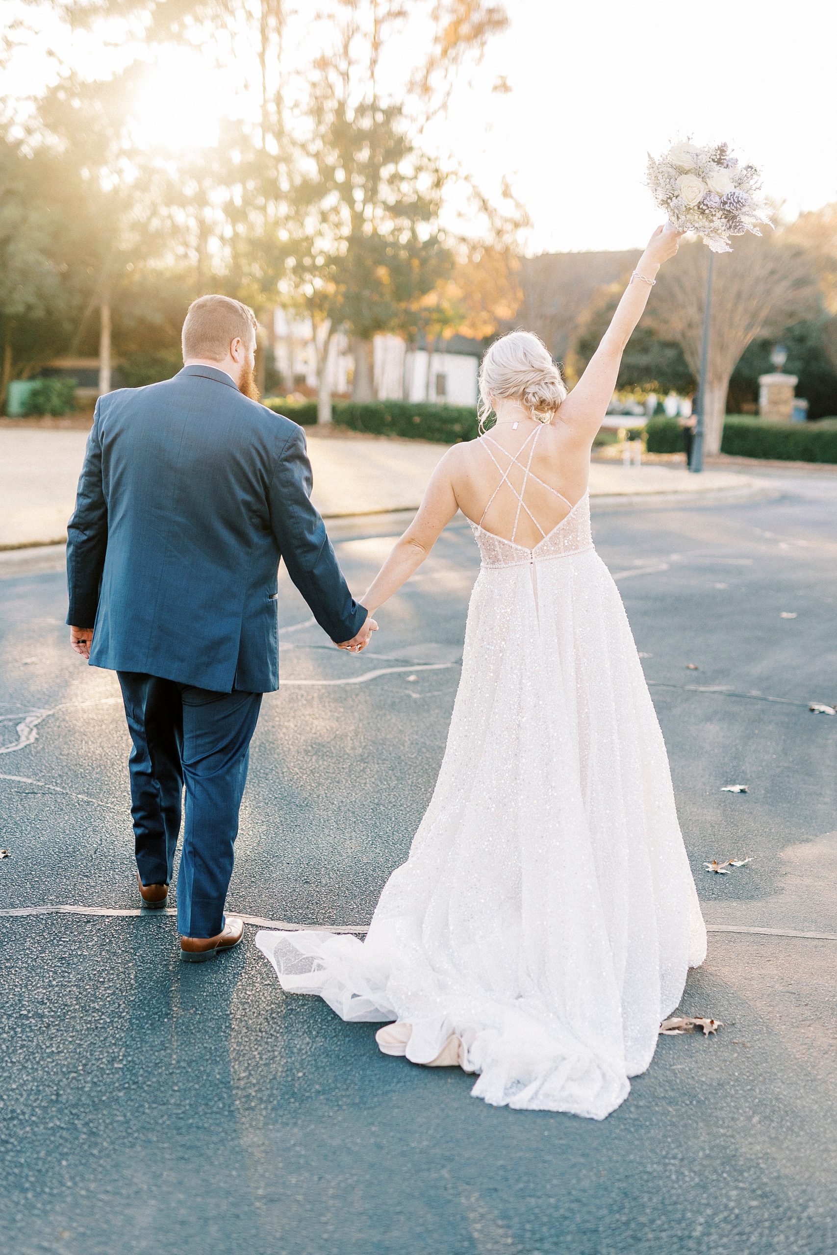 bride and groom hold hands walking towards River Run Country Club