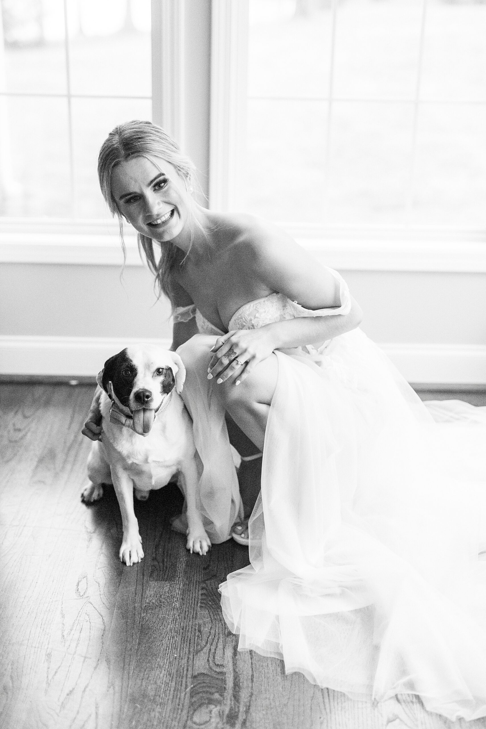 bride kneels with dog in wedding gown 