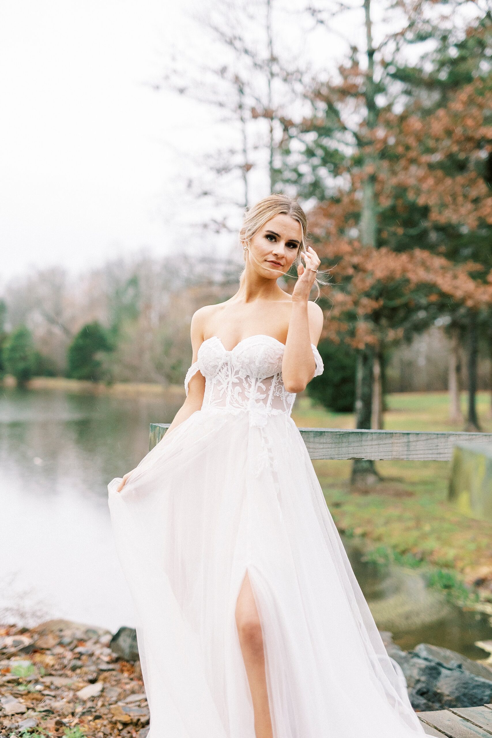 blonde woman in off-the-shoulder wedding gown pushes hair over ear 