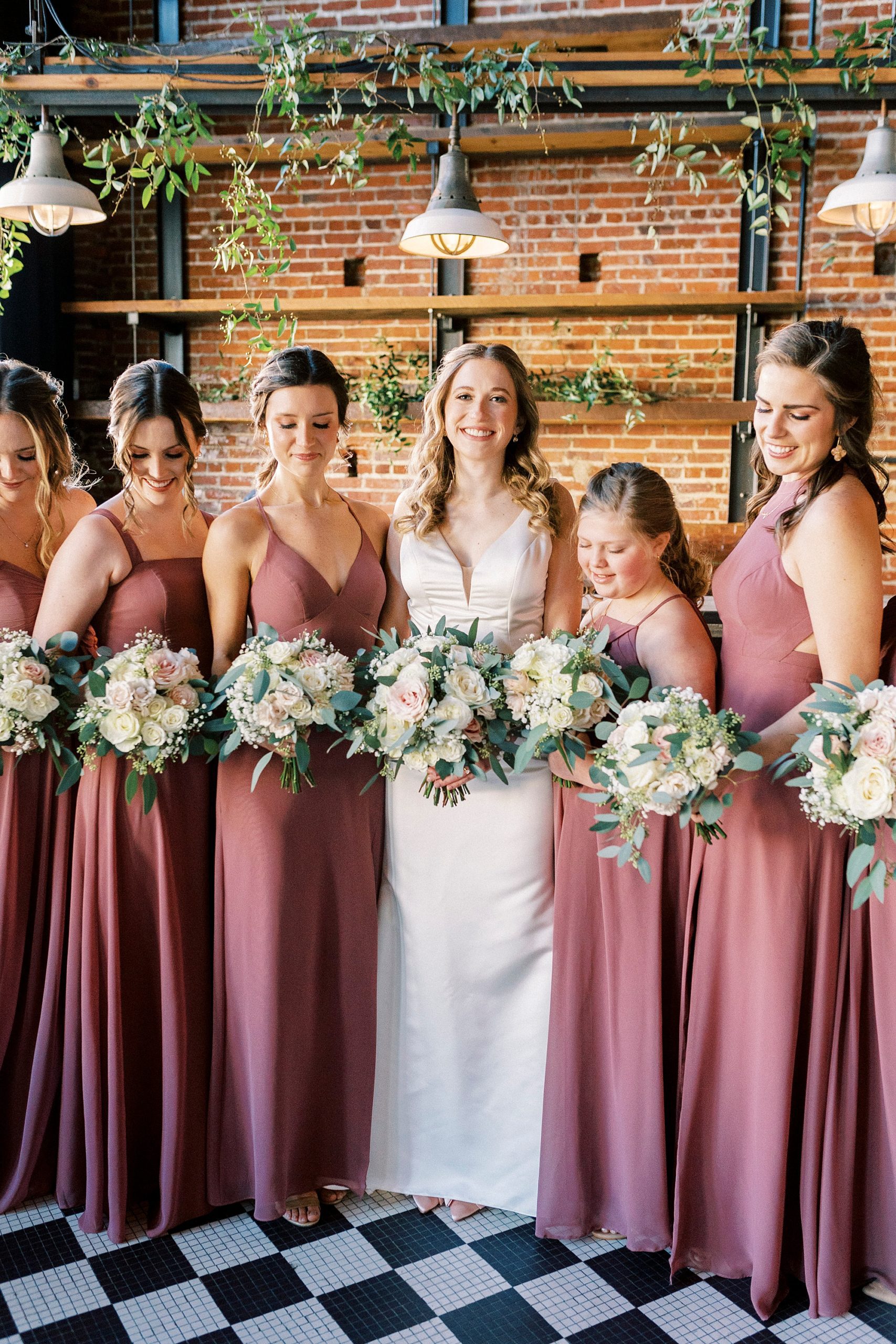 bride smiles with bridesmaids in pink gowns