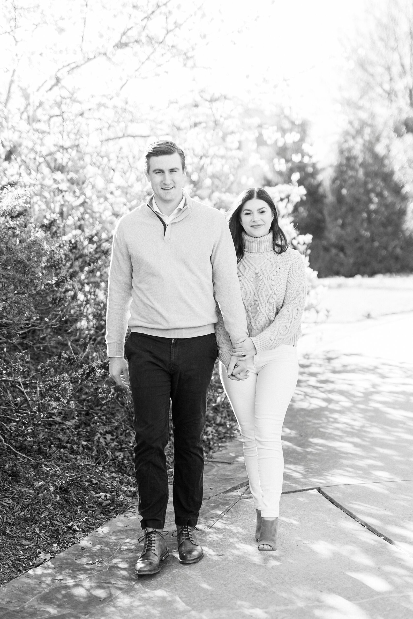 black and white portrait of couple walking through Elizabeth Park
