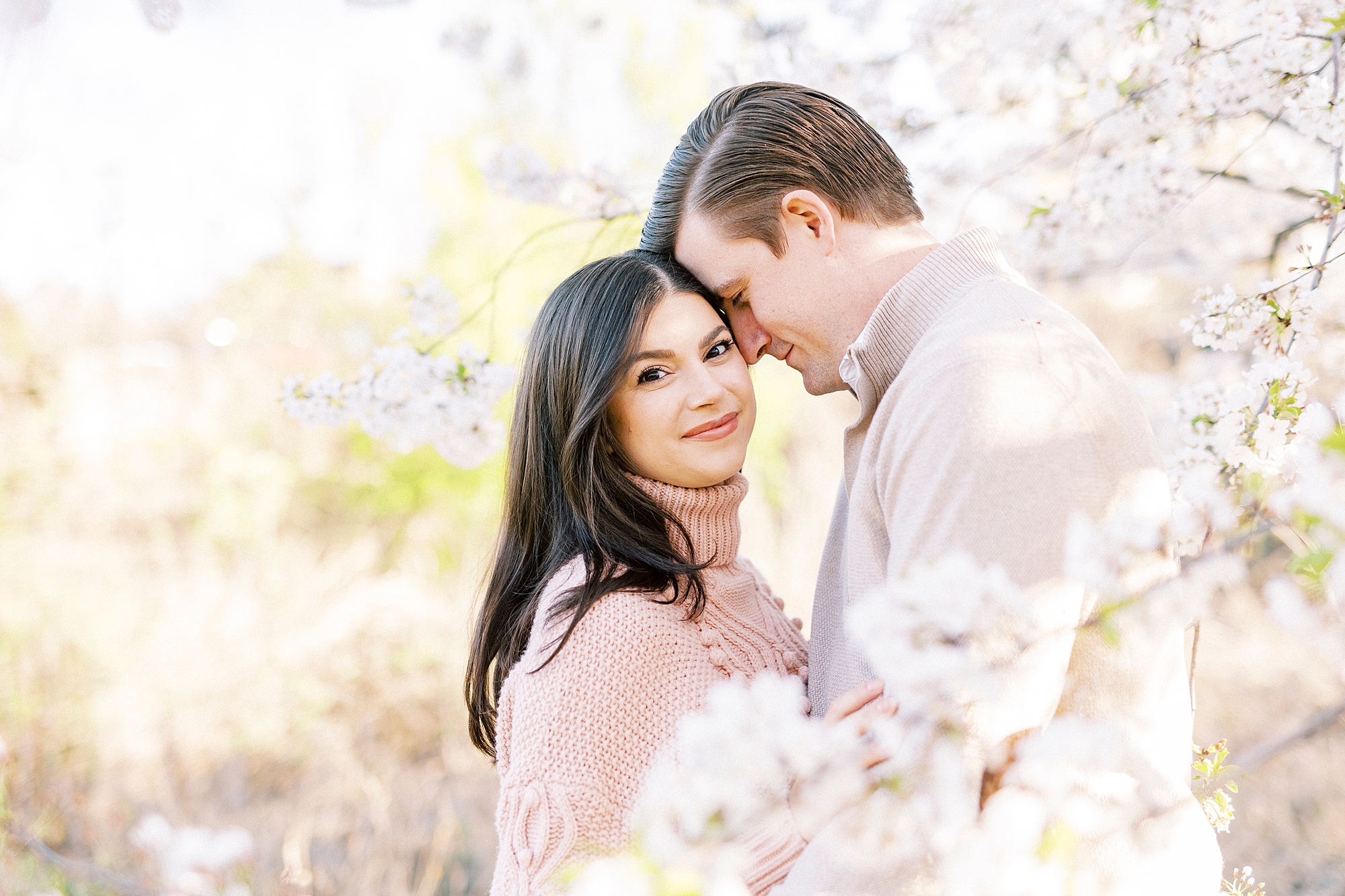 man leans down to woman and nuzzles her forehead during spring engagement session 
