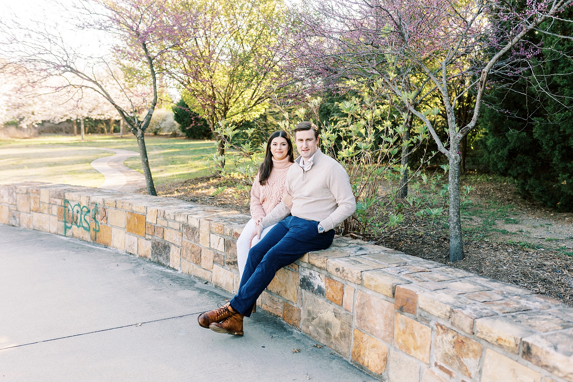 couple sits on brick wall inside Elizabeth Park