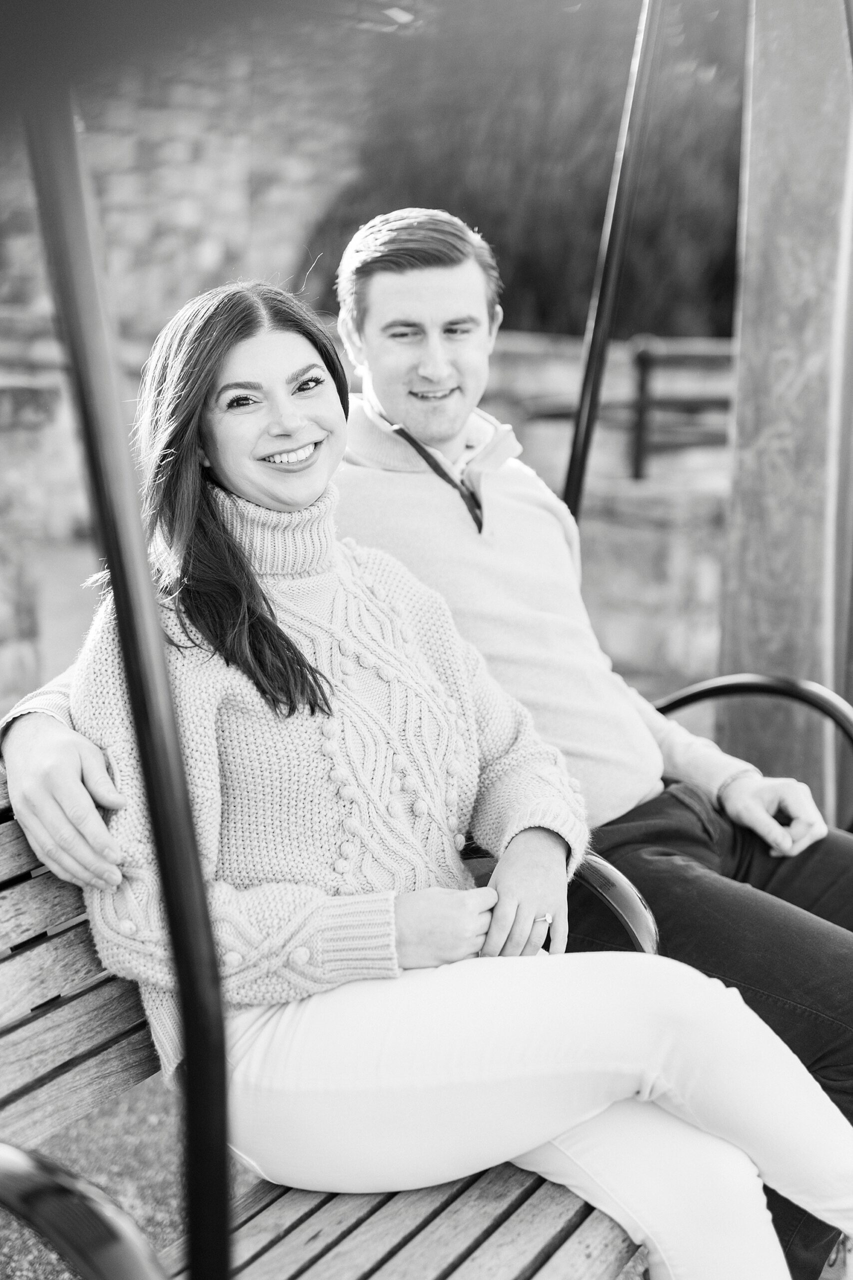 black and white portrait of couple sitting on swing 