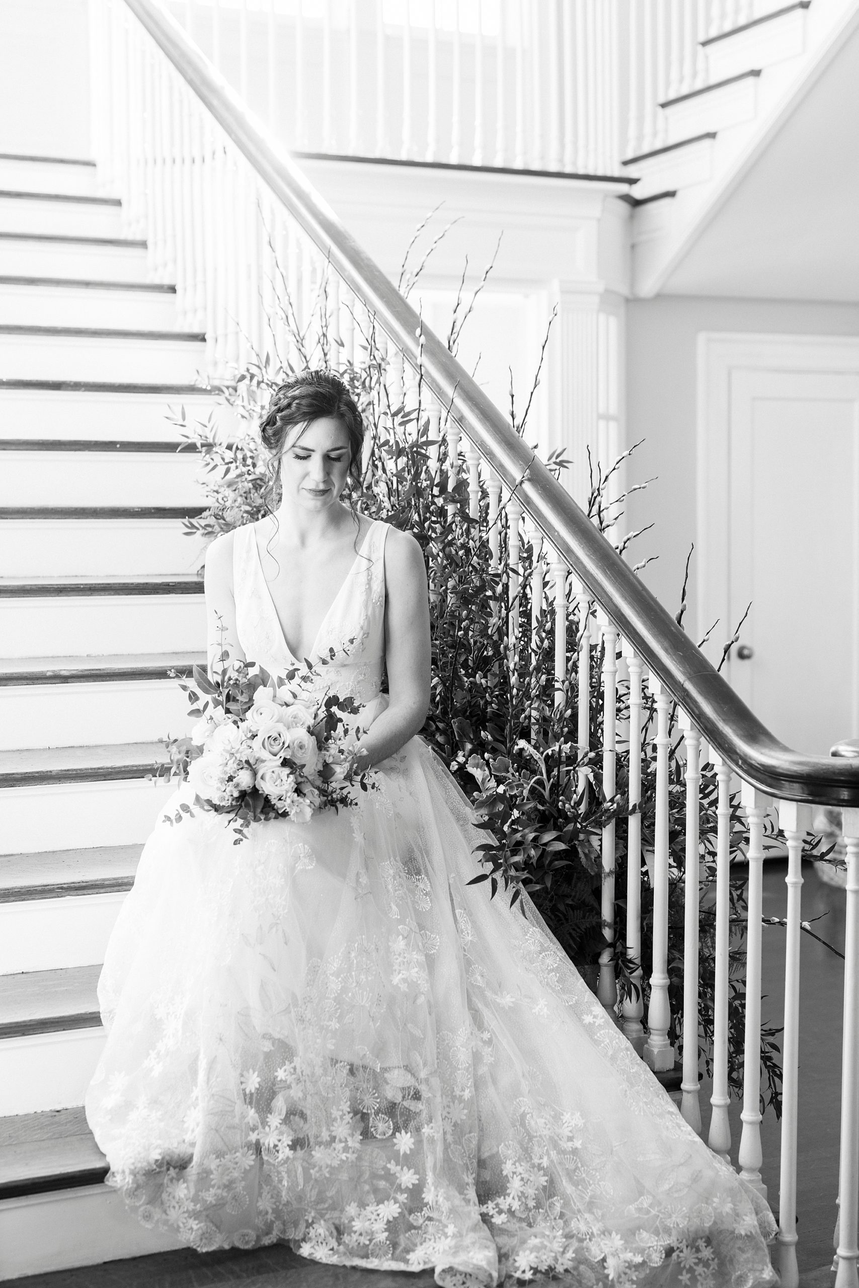 bride sits on staircase at Separk Mansion holding bouquet in lap 