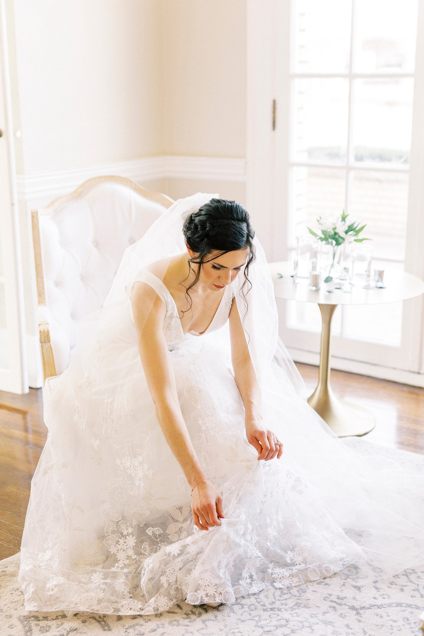 bride adjusts skirt of wedding gown 