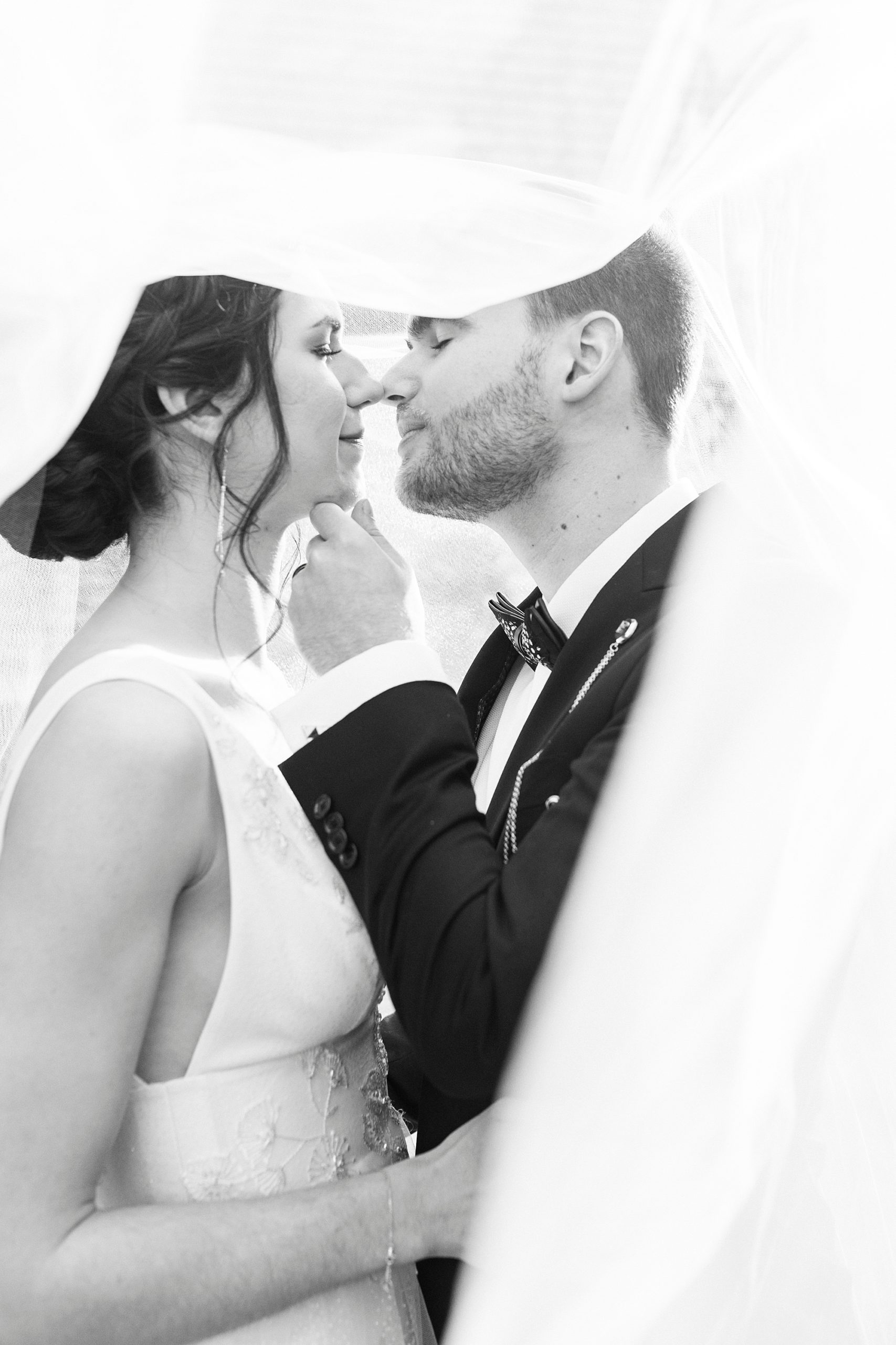 bride and groom touch noses under veil during portraits at Separk Mansion