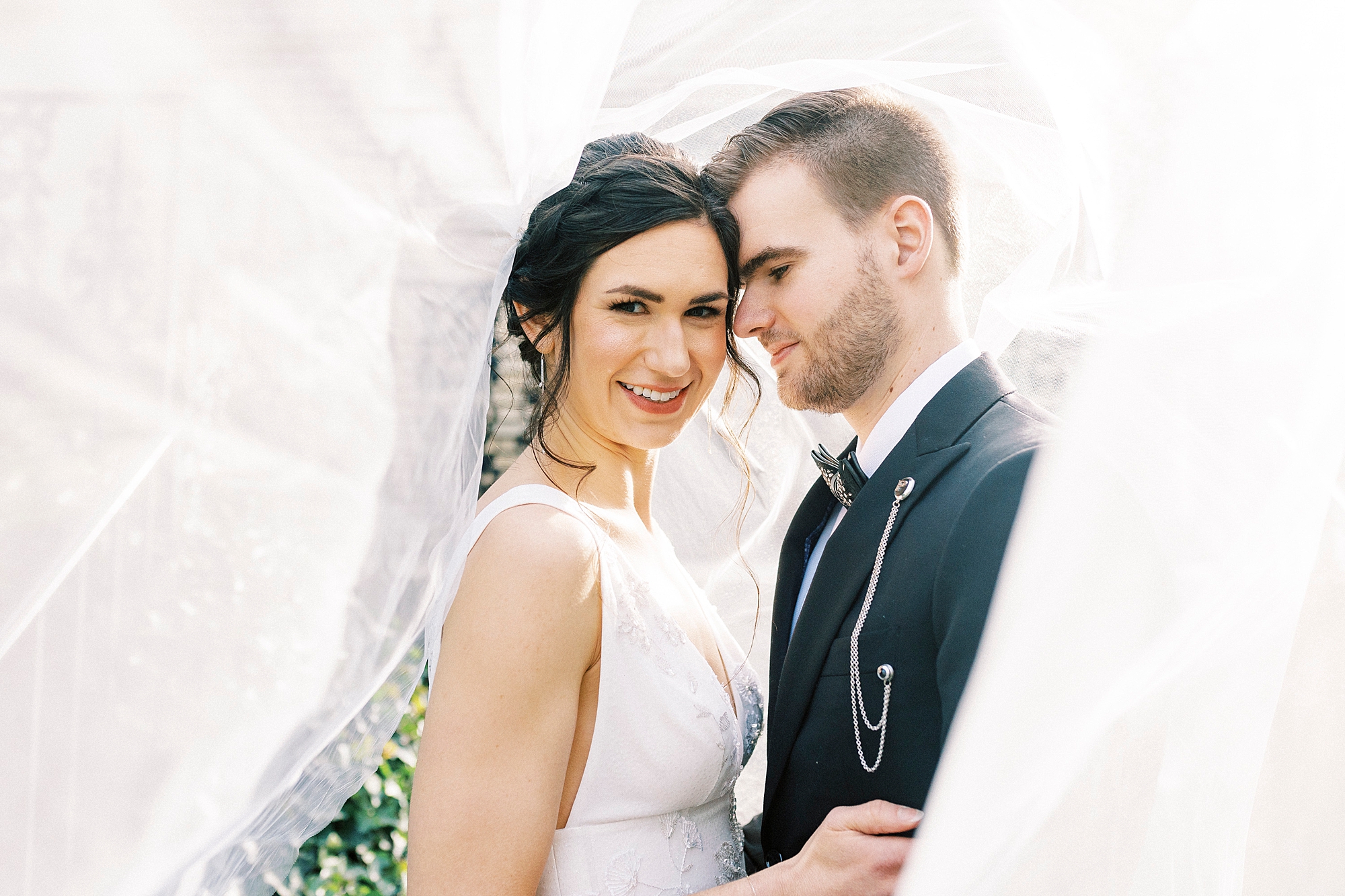 groom nuzzles bride's cheek under veil 