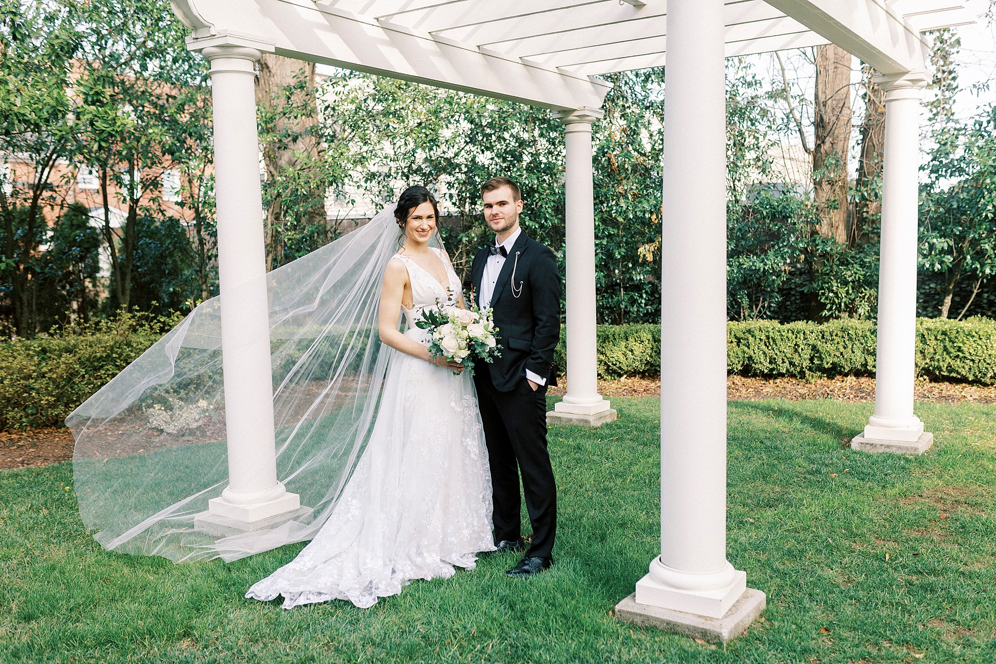 bride and groom hug under white arbor at Separk Mansion